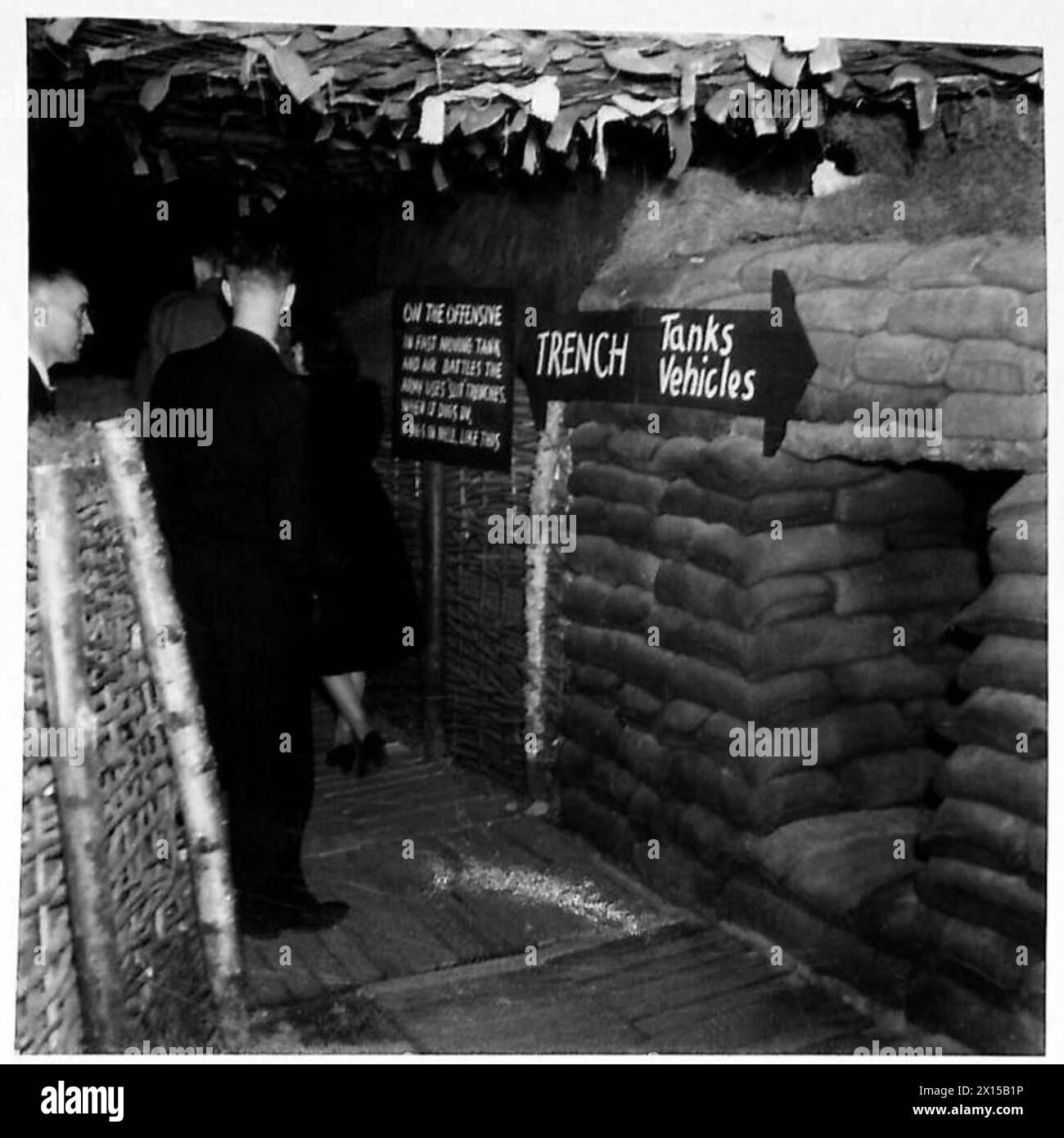 Les visiteurs d'une exposition d'équipement militaire inspectent les tranchées fendues conçues pour la protection des soldats et la défense sur le terrain. Banque D'Images