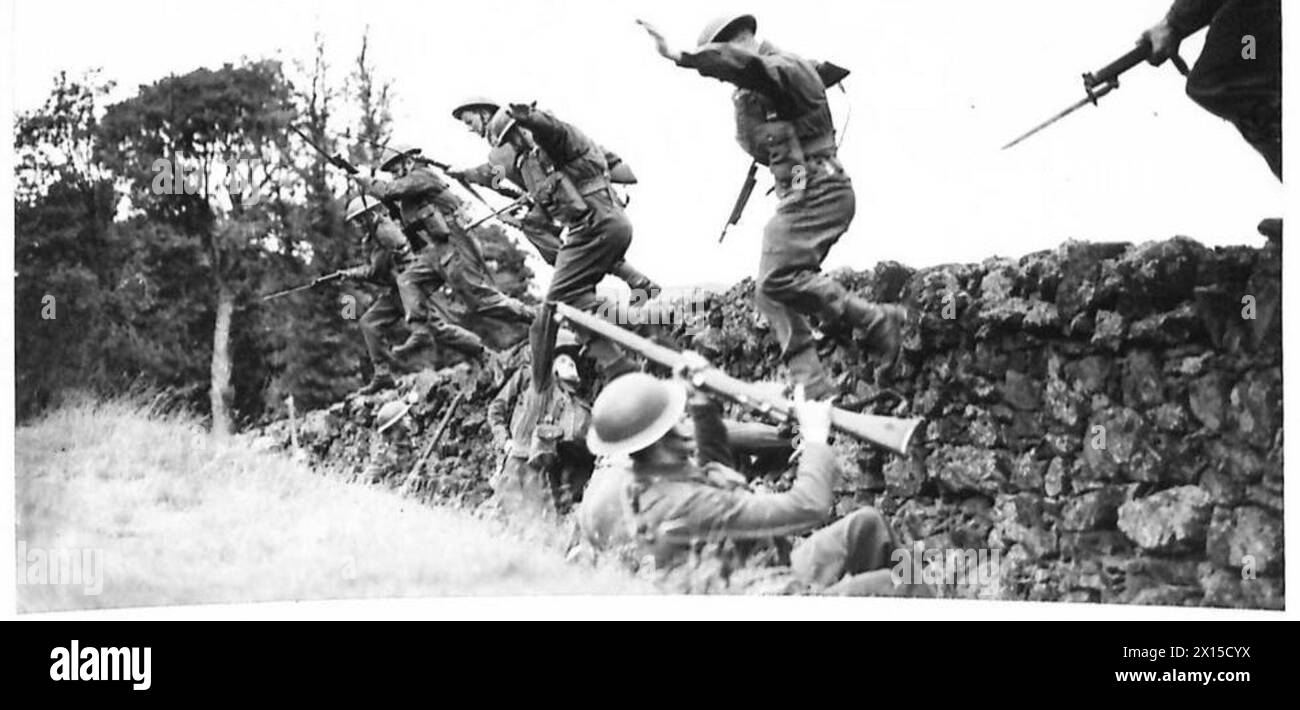 Les Camerounais surprennent des soldats « ennemis » qui se mettent à couvert derrière un mur lors d'un exercice frontalier à l'aide de baïonnettes et de pistolets Tommy. Banque D'Images
