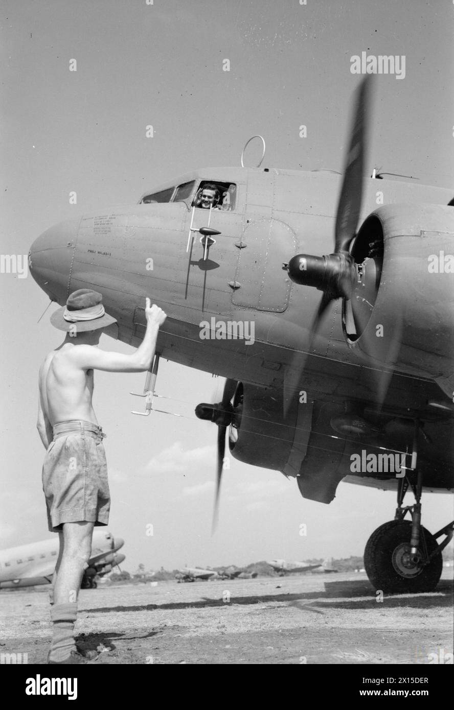 BIRMANIE : AU-DESSUS DE LA BOSSE AVEC LA R.A.F. - Cl.1266 : photo (publiée en 1945) montre - L'avion Dakota réchauffe ses moteurs à la dispersion tout en dirigeant l'avionneur T.A.Edwards de Craiglas Crescent, Cefn Forrest, Pengam, Blackwood, Mon., donne les pouces vers le haut Banque D'Images