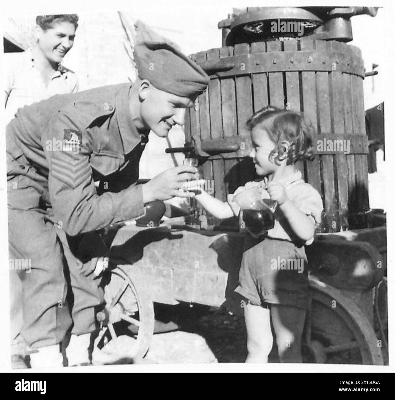 Le sergent Wratten de la huitième armée se voit offrir un échantillon de vin de Pietro Cantelio en Italie, illustrant l'interaction entre les soldats et les civils locaux. Banque D'Images