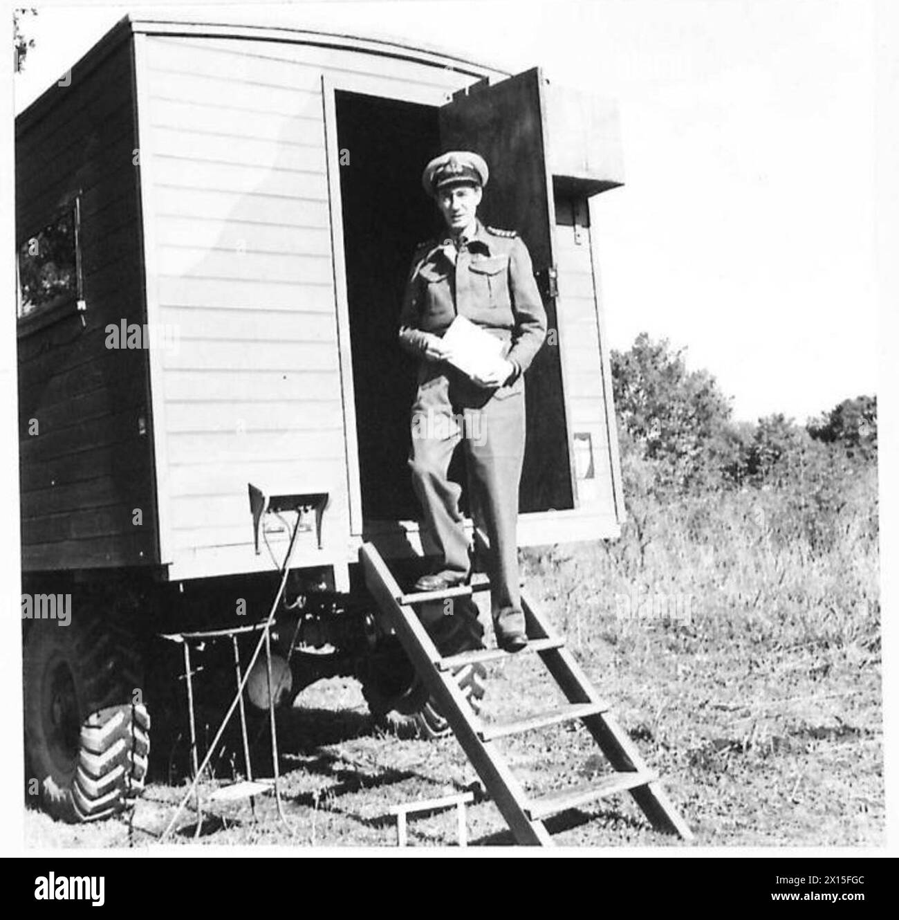 Le capitaine A.W. Clarke, DSO, officier de la Royal Navy, se tient à l'entrée de sa caravane tout en portant une tenue de bataille en Italie. Banque D'Images