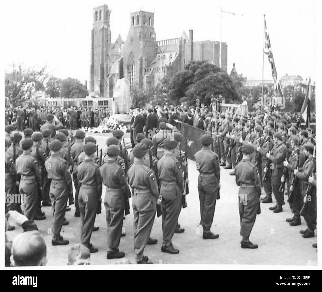 Des soldats britanniques et polonais présentent des armes au dévoilement du Mémorial d'Arnhem en septembre 1945, avec la cathédrale d'Arnhem en arrière-plan, en présence de la 1re division aéroportée, de la 1re brigade indépendante polonaise de parachutistes, du gouverneur néerlandais, le baron Aarnoud von Heemstra, des représentants de la Force intérieure néerlandaise et d'un chœur néerlandais à l'occasion de l'anniversaire de l'opération Market Garden. Banque D'Images