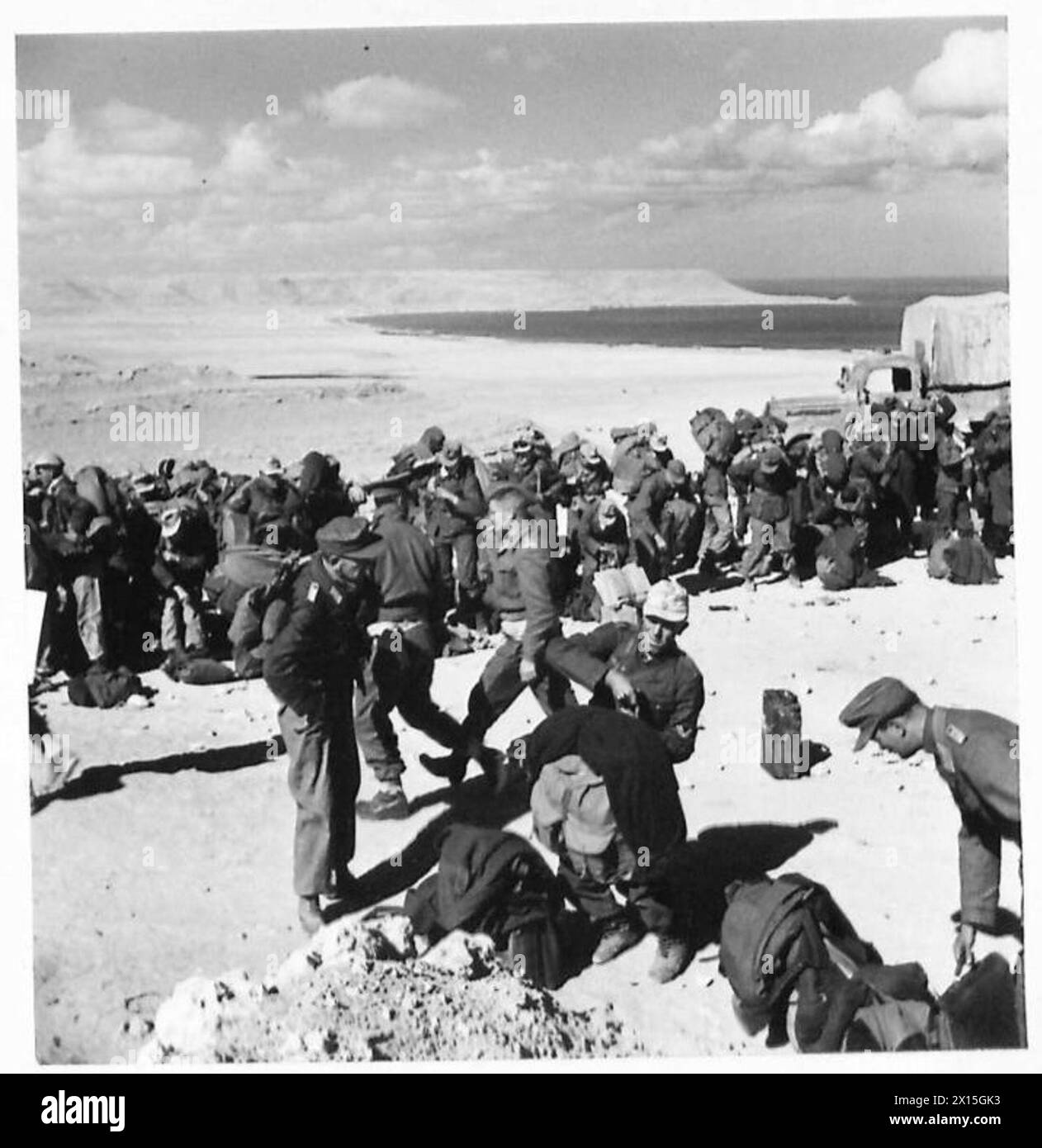 Deux fantassins jettent des fusils sur une barrière à double tablier, puis grimpent sur le fil pendant les opérations de l'armée. Banque D'Images