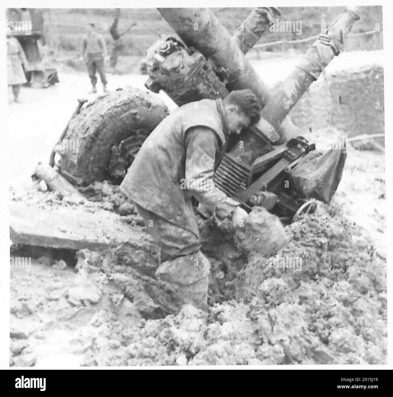 Un installateur de l'escouade de L.A.D. enlève la terre et la boue de la voie de roue d'un canon de campagne de 4,5 pouces pendant les opérations de récupération. Banque D'Images