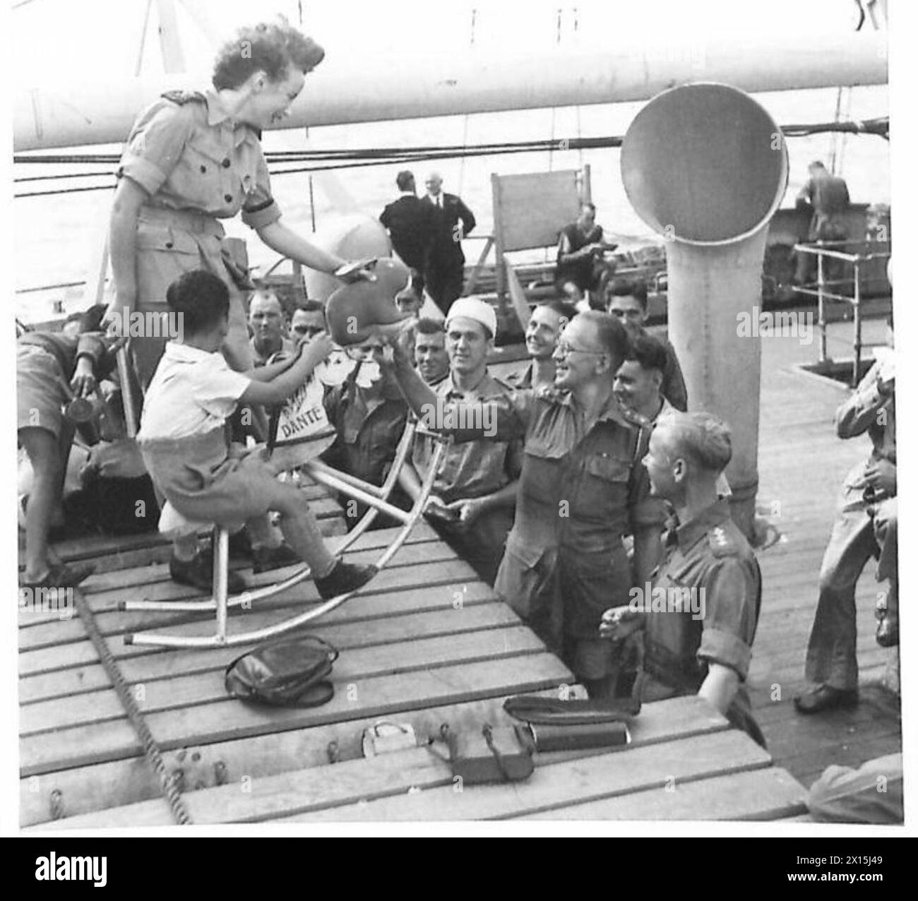 Les ex-prisonniers de guerre et les internés civils de Singapour reçoivent des jouets fabriqués par la R.A.O.C., distribués par Miss Anne Small de la Croix-Rouge britannique. Banque D'Images