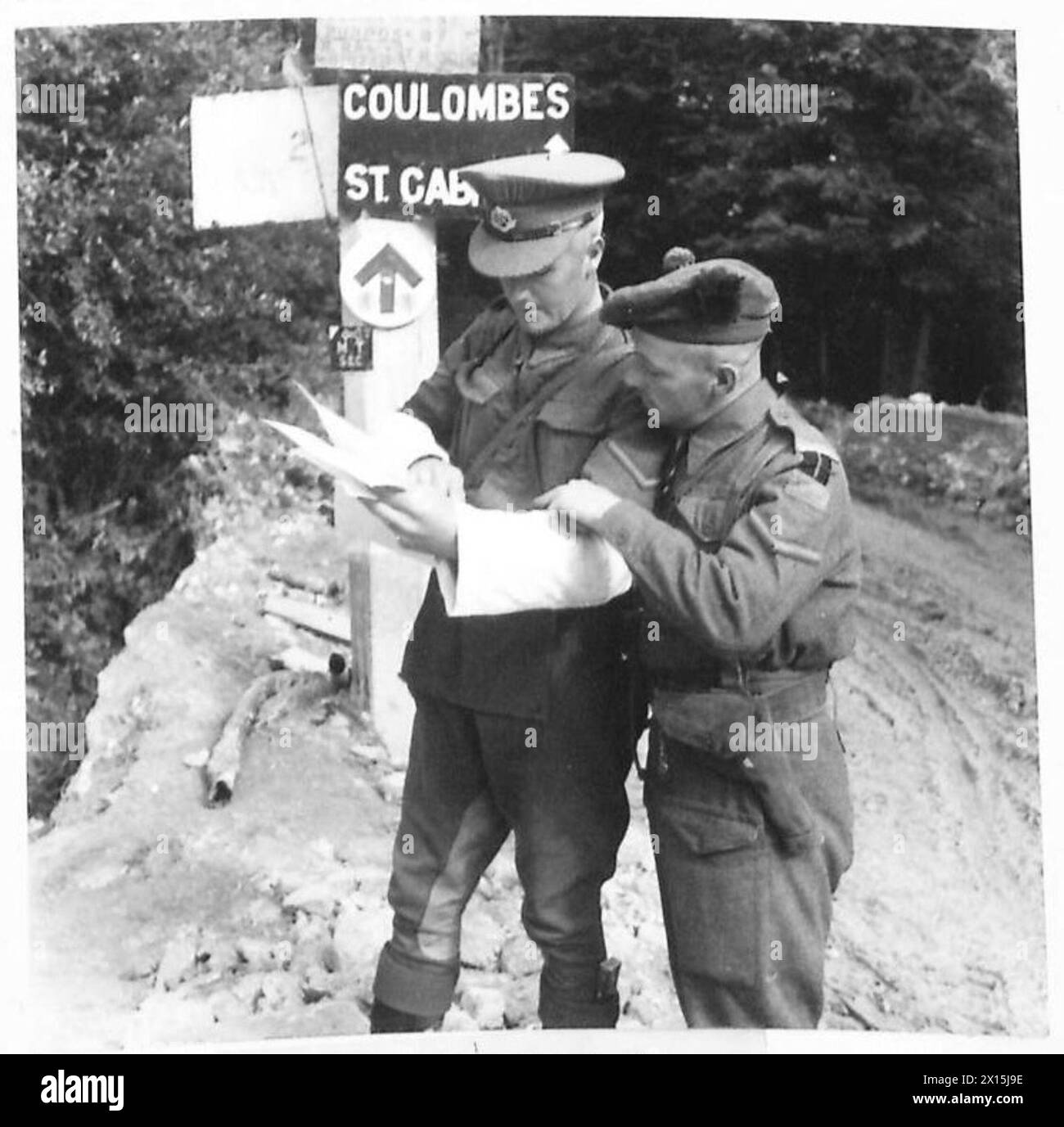 Le caporal Lang du CMP fournit une référence cartographique au caporal McFarlane du 1er bataillon, Highland Light Infantry, sur Cully Road en Normandie pendant les opérations du 21e groupe d'armées de l'armée britannique. Banque D'Images