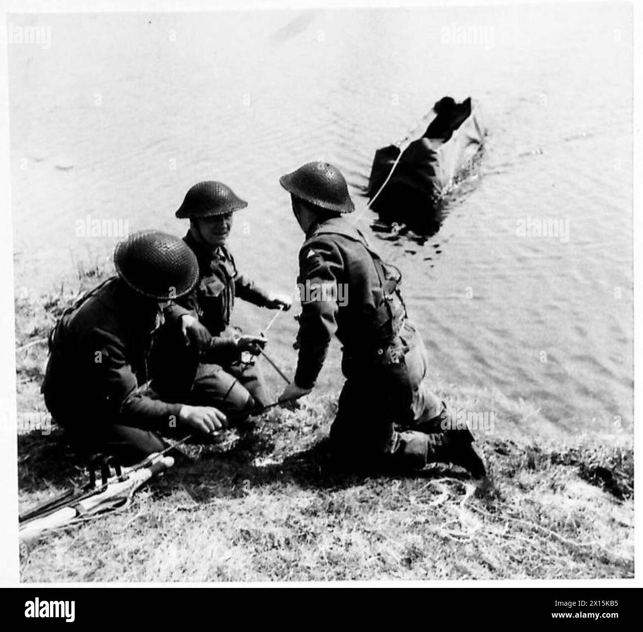 Le personnel du corps médical de l'armée britannique passe un brancard à travers une rivière, employant des techniques de style commando pendant l'entraînement. Banque D'Images