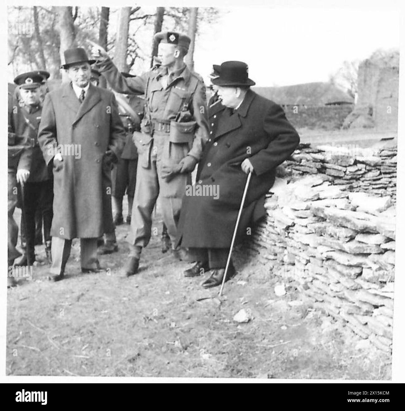 Le premier ministre et l'ambassadeur turc observent un exercice militaire assis sur un mur de pierre. Banque D'Images