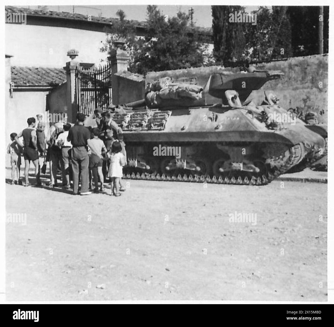 Des civils italiens observent des canons automoteurs stationnés le long de la via Andrea Del Sarto alors que la 8e armée britannique établit une tête de pont sur l'Arno pendant la seconde Guerre mondiale Banque D'Images