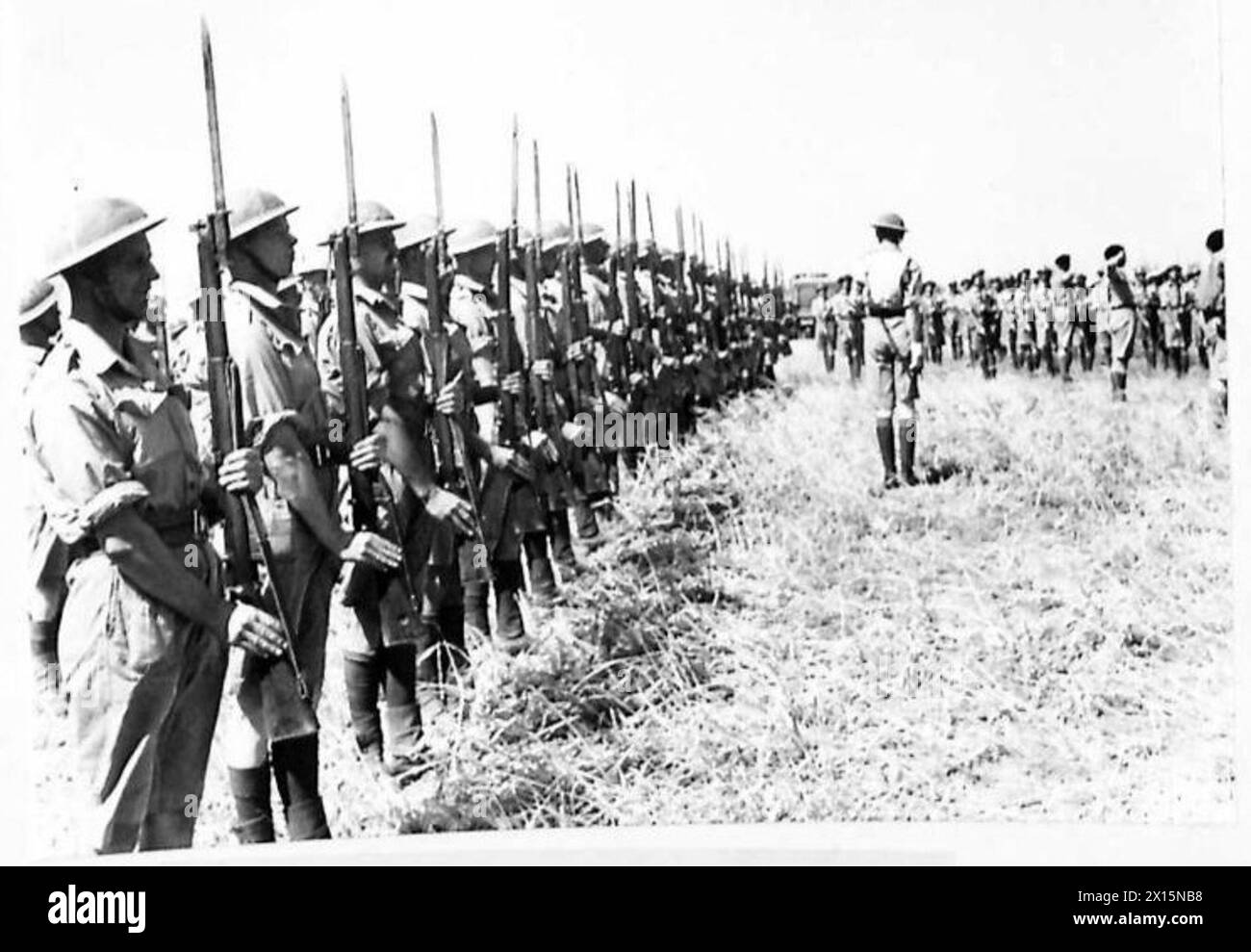 LE COMMANDANT DIVISIONNAIRE REND VISITE AUX GARDES DE GRENADIERS - lors d'un défilé, d'un tour et d'une passe après les combats tunisiens, les gardes « présentent des armes » alors que le général Keightley arrive pour inspecter l'armée britannique de la parade Banque D'Images