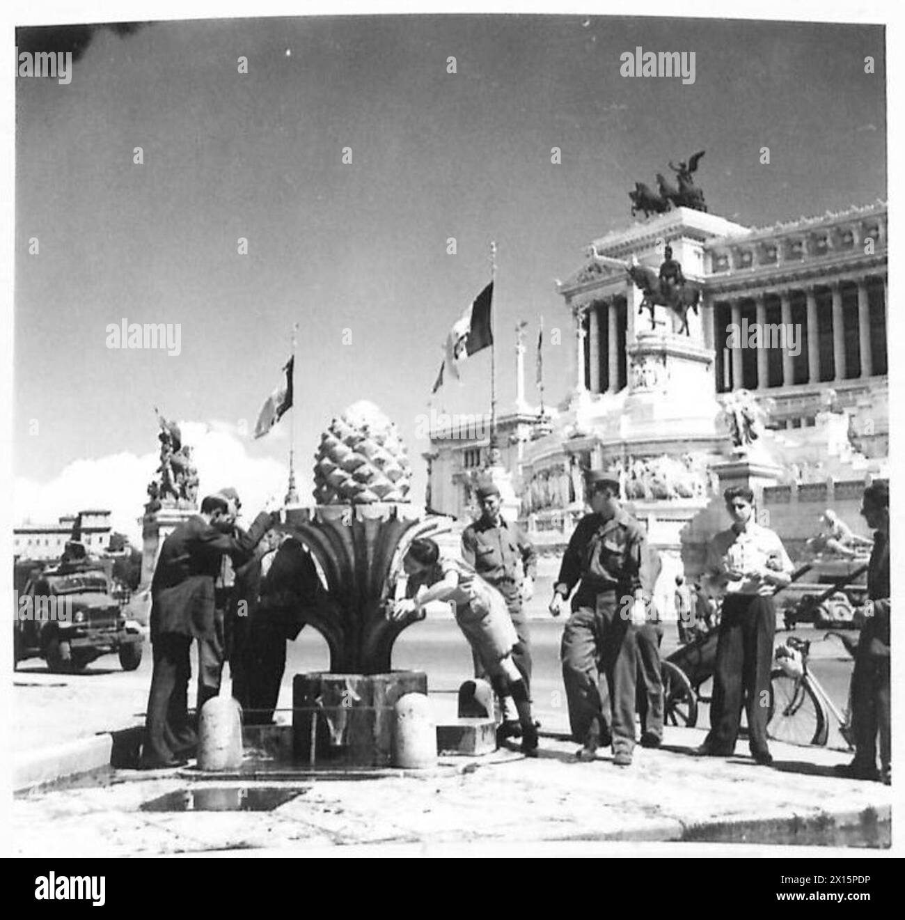 Gunner Smith boit dans une fontaine de Piazza Venezia, Rome, après avoir marché sous le soleil. Le Mémorial Victor-Emmanuel II et la tombe du guerrier inconnu sont visibles à l'arrière-plan, British Army. Banque D'Images