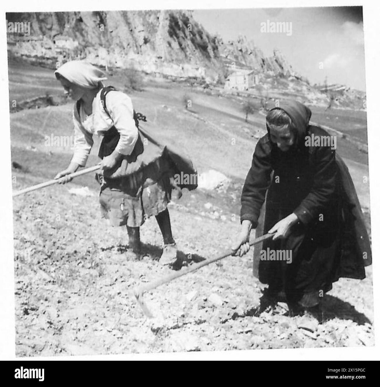Des guérilleros italiens sont observés dans les montagnes Apennins tandis que les travailleurs locaux poursuivent leurs opérations agricoles, avec la présence de l'armée britannique notée. Banque D'Images