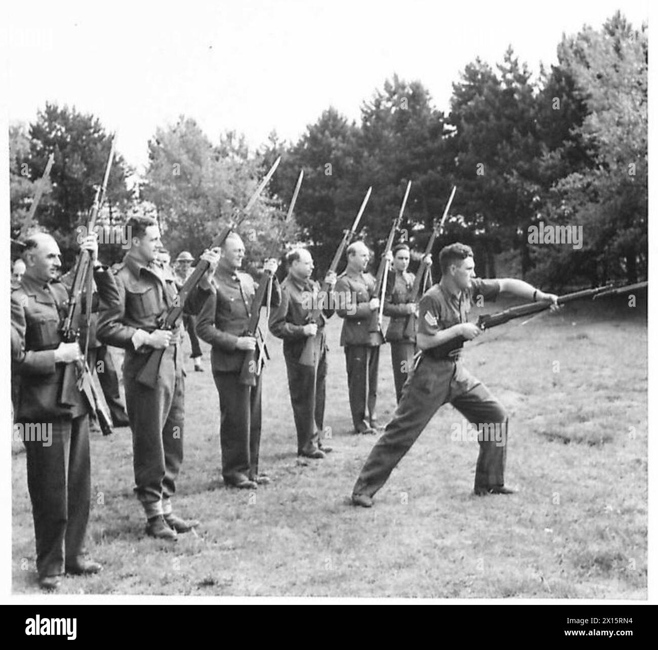 Les correspondants de guerre essaient des exercices à baïonnette lors d'une visite au Eastern Command's Coast Regiment, observant l'entraînement et les routines militaires de l'armée britannique. Banque D'Images