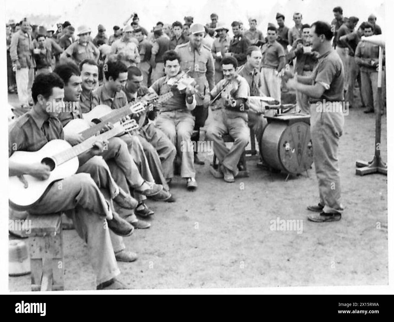 Dans un camp de prisonniers de guerre britanniques, les prisonniers fabriquaient des instruments de musique à partir de caisses d'emballage, de boîtes de pétrole et de fils, formant un groupe pour maintenir le moral. Banque D'Images