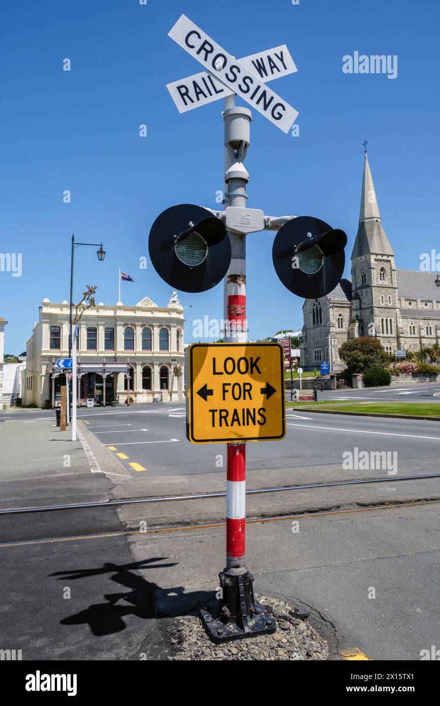 Passage de chemin de fer dans Thames Street et vue sur l'église anglicane St Luke et l'ancien bâtiment AMP, Oamaru, Otago, Île du Sud, Nouvelle-Zélande Banque D'Images