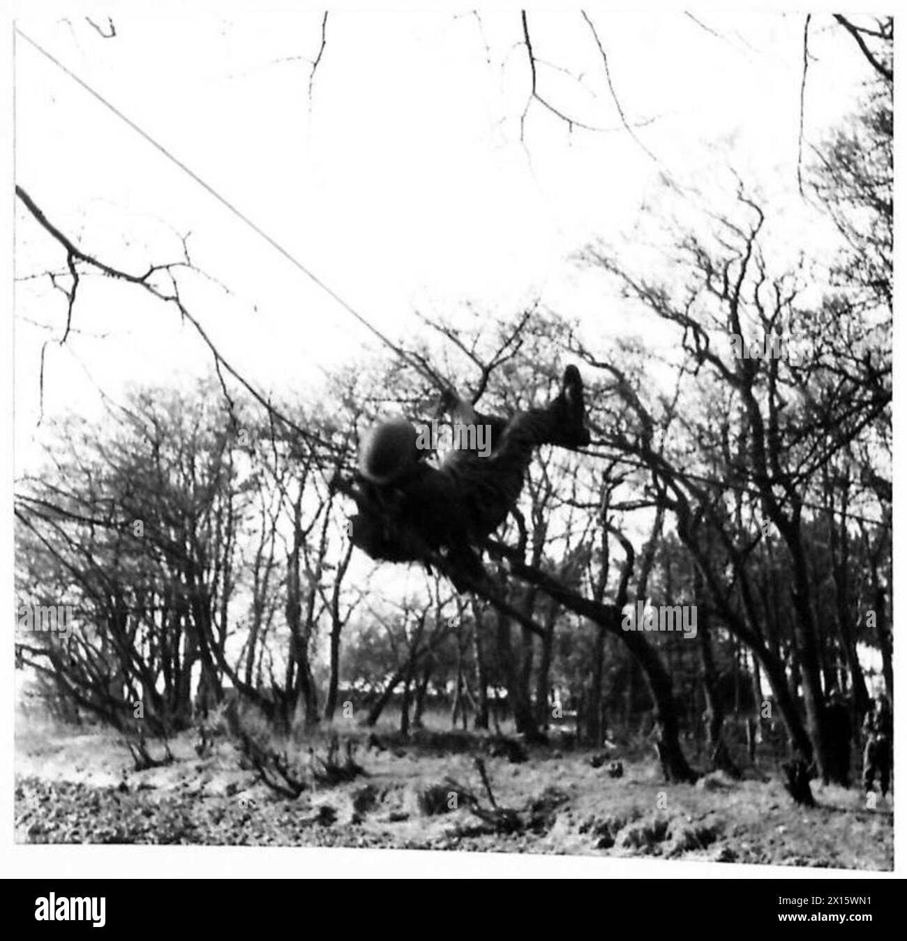 Les commandos de l'armée britannique pratiquent un exercice d'entraînement en traversant une rivière à l'aide d'une seule corde, démontrant la furtivité, l'équilibre et la coordination physique. Banque D'Images