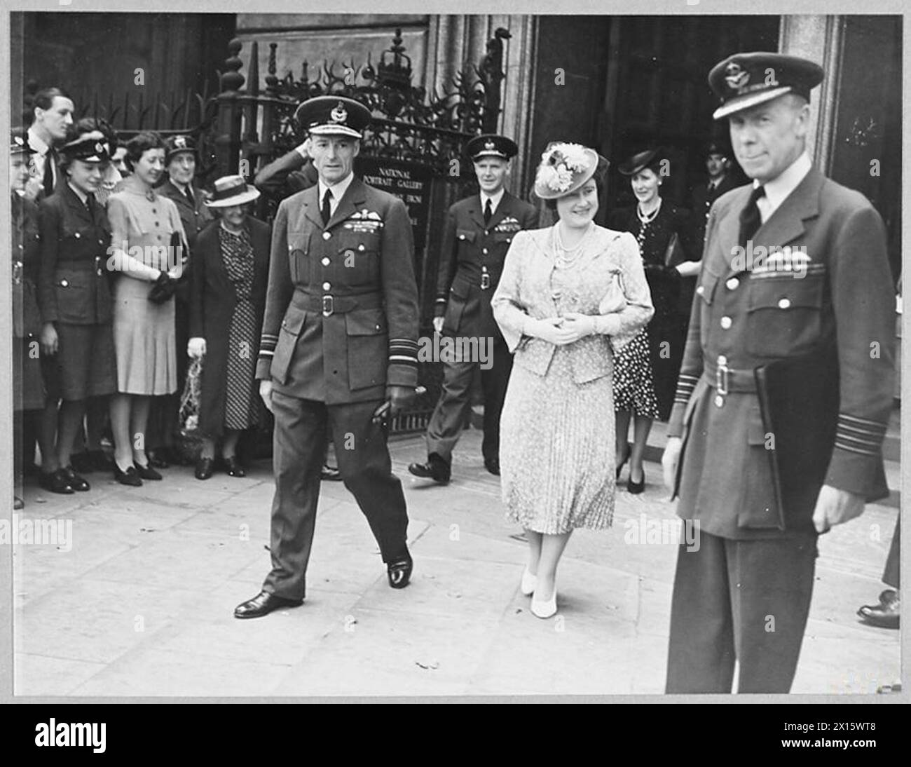 Spectacles Queen visitant une exposition d'art et d'artisanat de W.A.A.F. en 1943, accompagnée par des officiers supérieurs de la RAF, mettant en lumière les activités créatives en temps de guerre. Banque D'Images