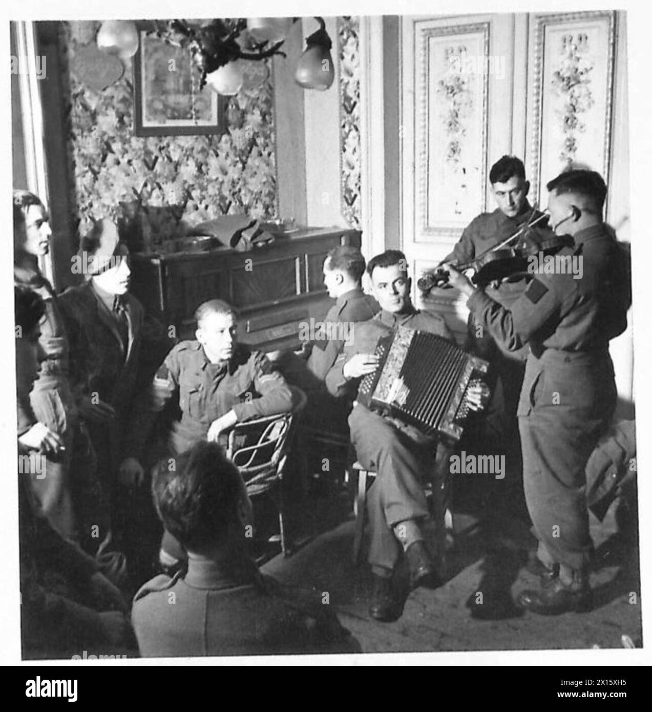 Les membres du 5th Seaforth Highlanders Pipe Band interprètent de la musique sur une billette, en utilisant du piano, de l'accordéon et des violons, avec un soutien vocal, armée britannique, 21e groupe d'armées. Banque D'Images