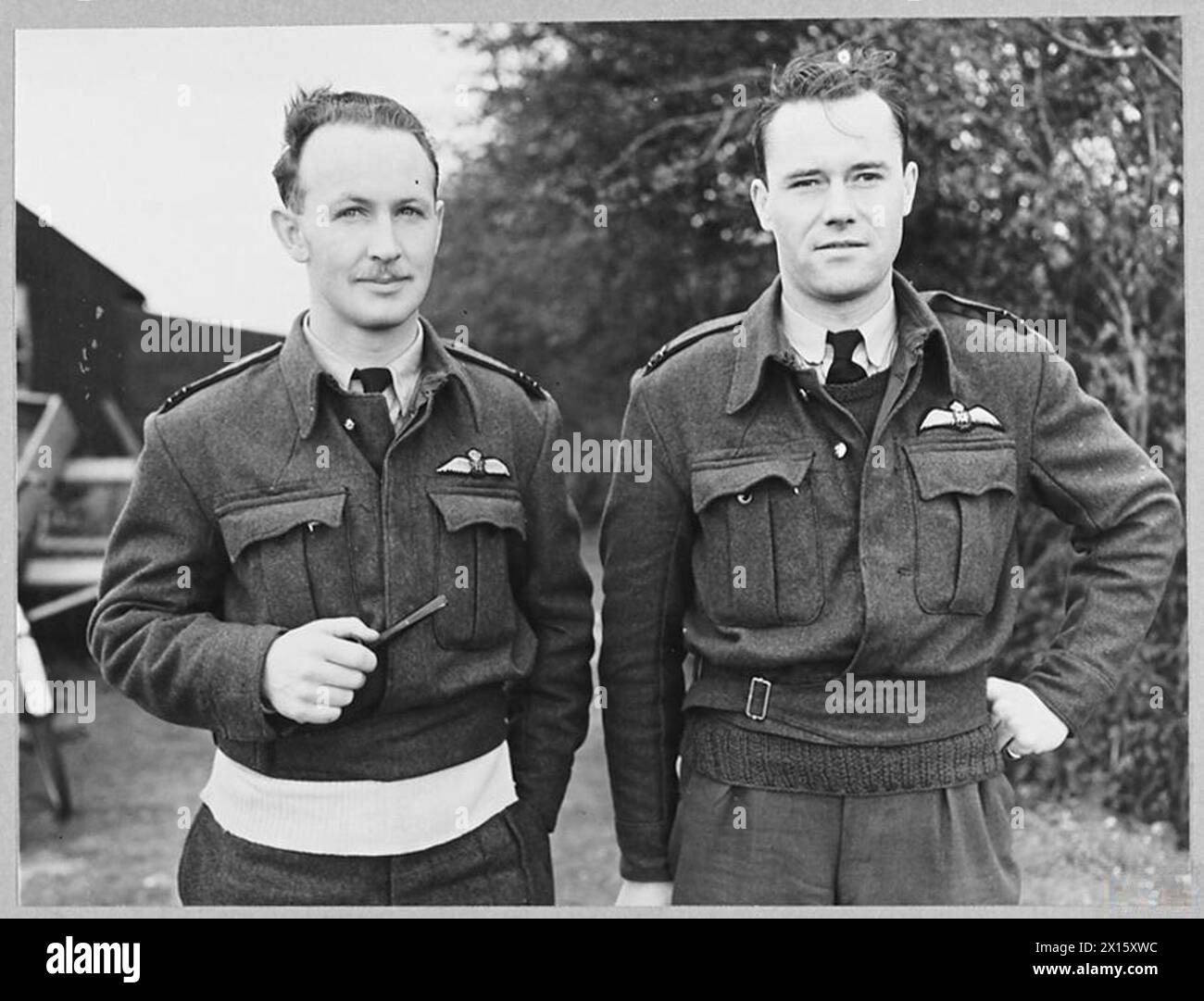PILOTES DE CHASSE ACE DE LA R.A.F. - pilotes de chasse Ace de la R.A.F. opérant à partir d'une station en Grande-Bretagne - des hommes qui gardent le ciel au-dessus de la Grande-Bretagne une «zone de danger» pour les avions ennemis et qui démontrent au-dessus de l'Europe occupée la puissance du chasseur comme une arme offensive. (Photo publiée en 1943). Deux des pilotes de chasse ACE de la RAF - de gauche à droite - Flight Lieutenant E.P. Wood, Flight Lieutenant R.A. Buckam Royal Air Force Banque D'Images