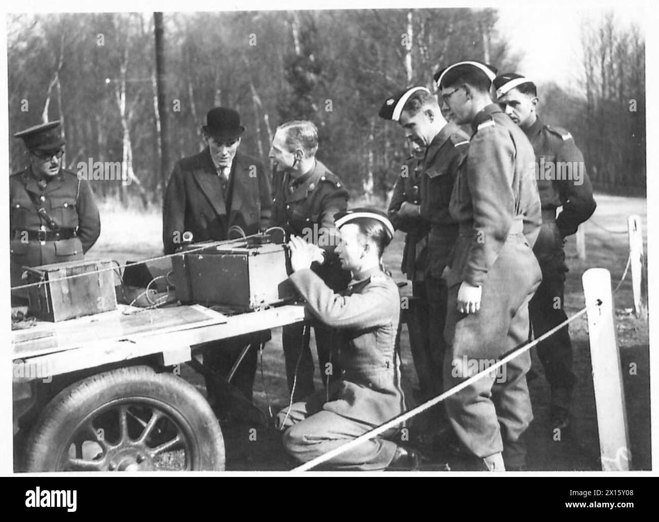 Le secrétaire d'État visite Sandhurst, observant des cadets en formation dans un poste sans fil sur le terrain. Banque D'Images