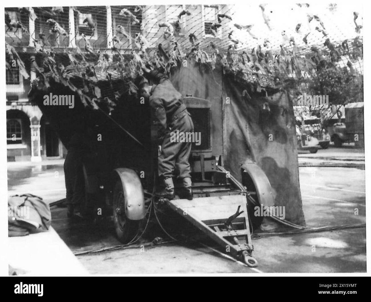 Le personnel de l'armée britannique applique un camouflage à une remorque génératrice alimentant une unité de blanchisserie mobile, assurant ainsi la sécurité opérationnelle et la dissimulation pendant le déploiement. Banque D'Images Le personnel de l'armée britannique applique un camouflage à une remorque génératrice alimentant une unité de blanchisserie mobile, assurant ainsi la sécurité opérationnelle et la dissimulation pendant le déploiement. Banque D'Images
