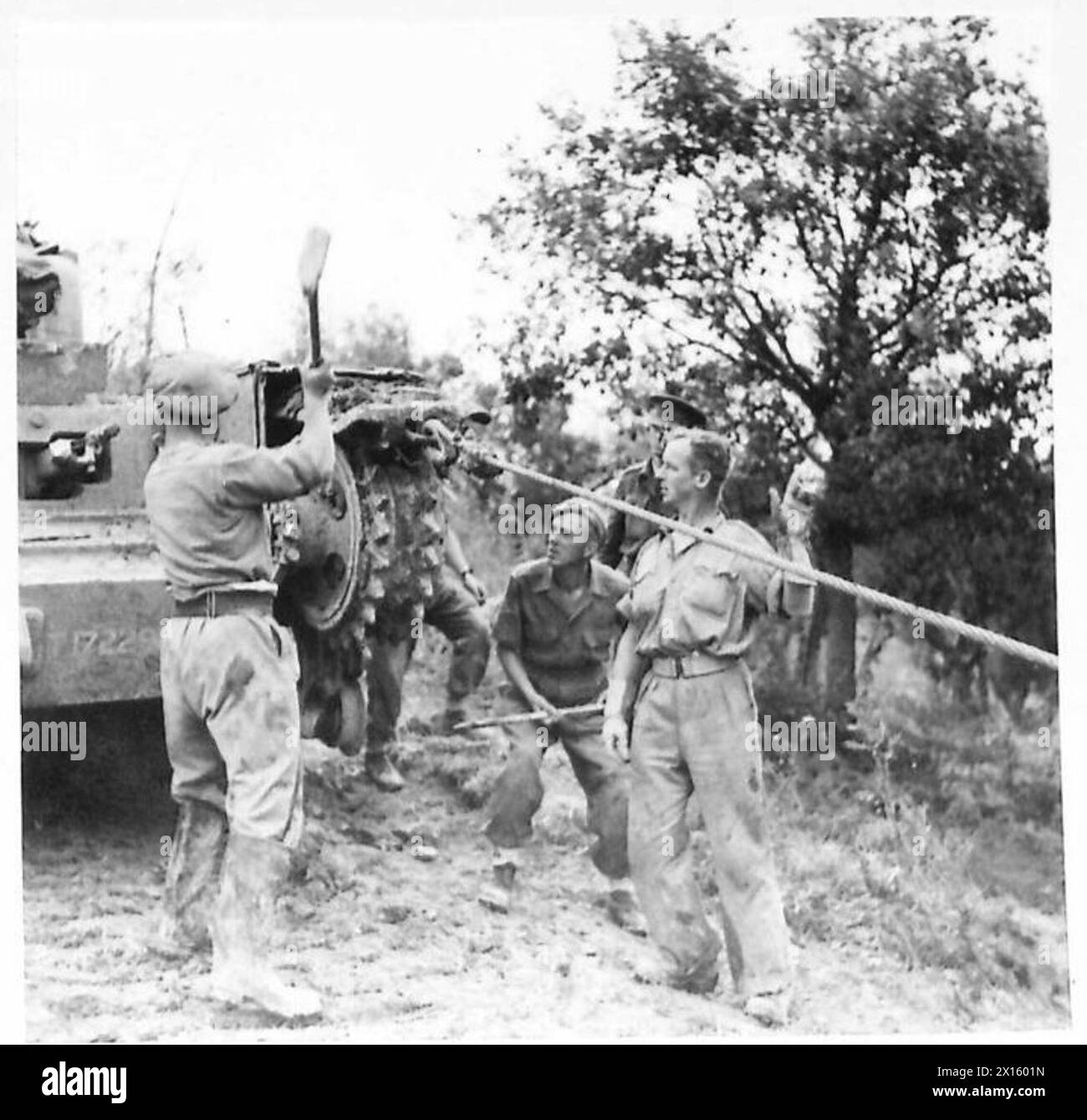 Le personnel de la huitième armée ajuste une voie sur un véhicule, la positionnant sur la roue de tension avant après la pluie. Banque D'Images