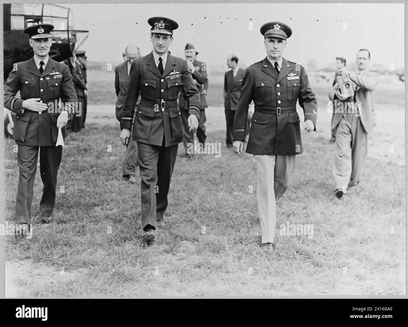 Sir Charles Portal et le général Chaney marchent vers un avion de la Royal Air Force, indiquant une inspection ou un départ. Banque D'Images