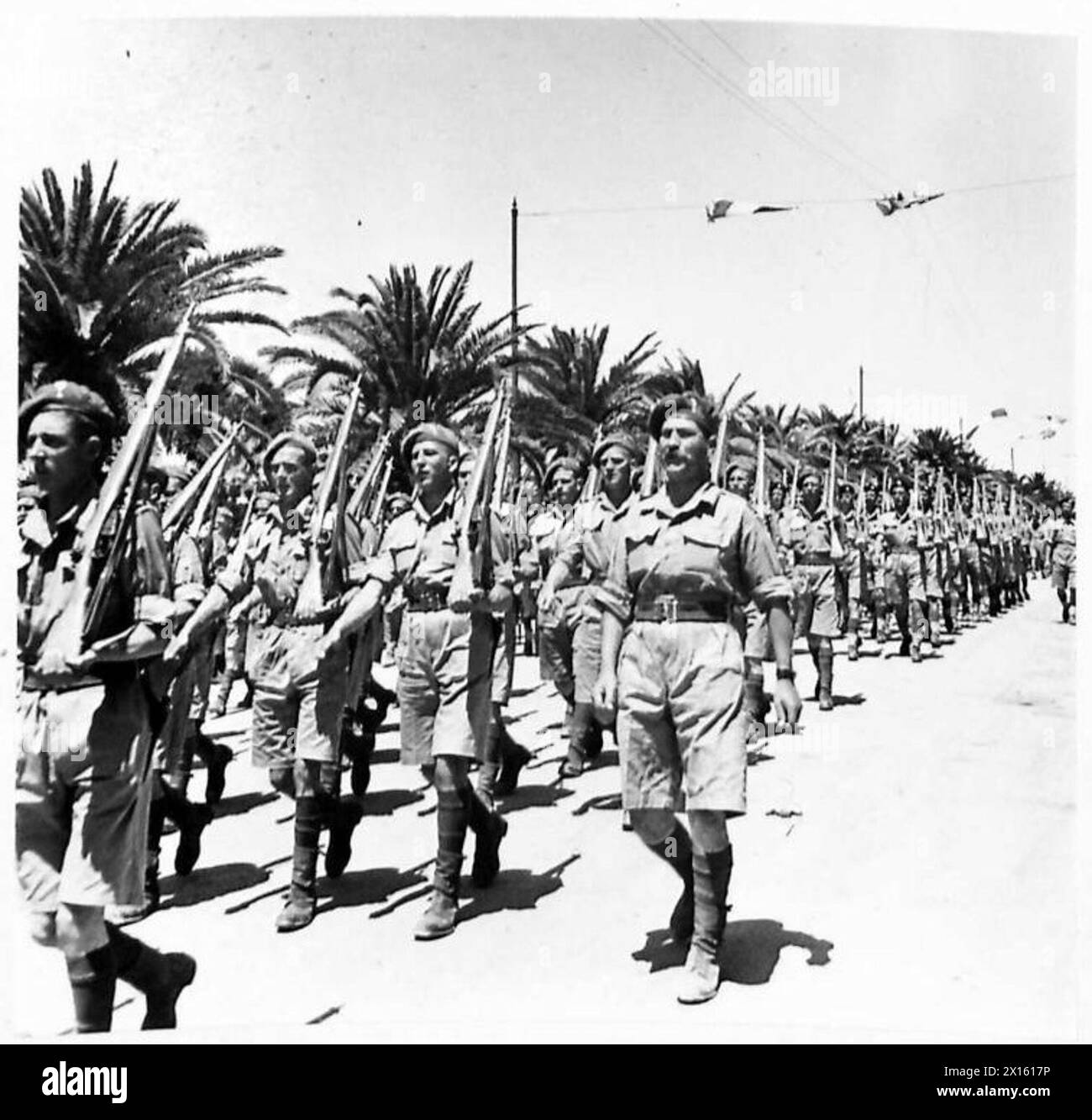 Les troupes britanniques participent à un défilé de célébration de la victoire à Tunis, démontrant la formation militaire et les devoirs cérémoniels. Banque D'Images