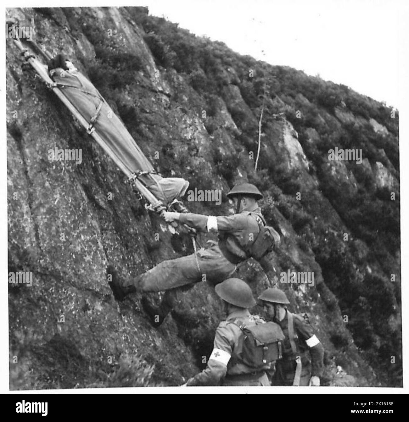 Les porteurs de brancards du RAMC transportent un homme blessé jusqu'à une falaise en Irlande du Nord lors d'un exercice simulant des conditions de bataille similaires à celles de la Sicile, démontrant une réponse médicale et la prise en charge des victimes. Banque D'Images Les porteurs de brancards du RAMC transportent un homme blessé jusqu'à une falaise en Irlande du Nord lors d'un exercice simulant des conditions de bataille similaires à celles de la Sicile, démontrant une réponse médicale et la prise en charge des victimes. Banque D'Images