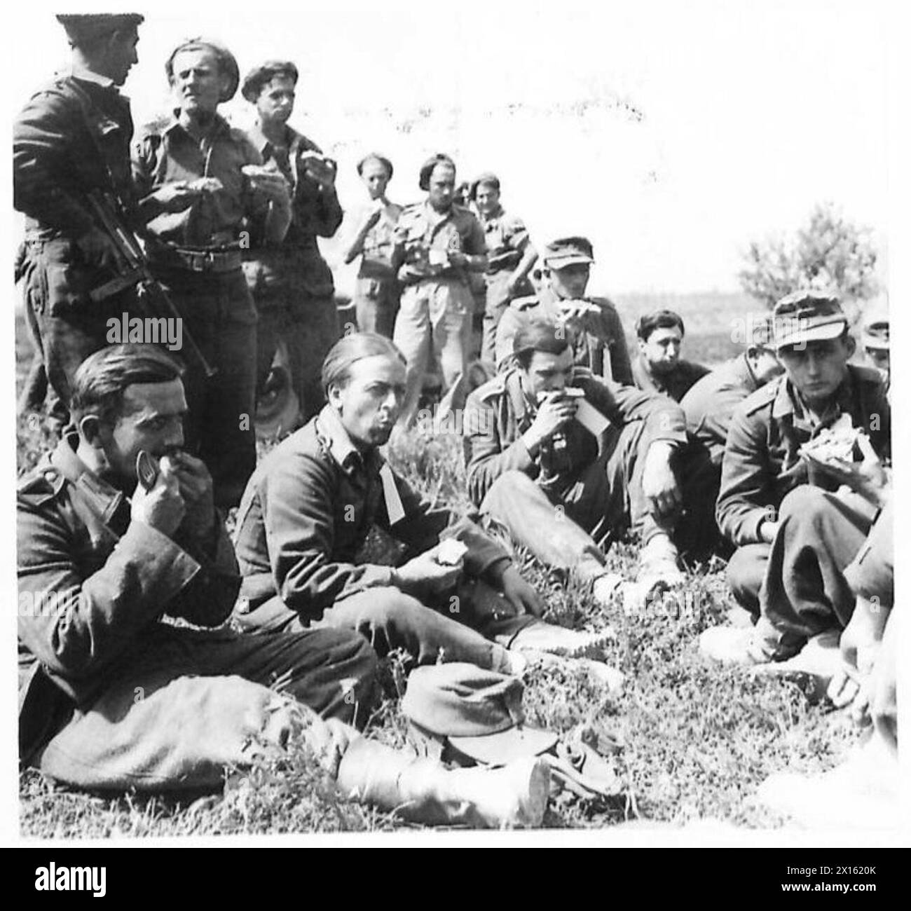 Les soldats allemands, y compris les parachutistes, reçoivent leur premier repas en tant que prisonniers de guerre sous la supervision de la huitième armée britannique. Banque D'Images