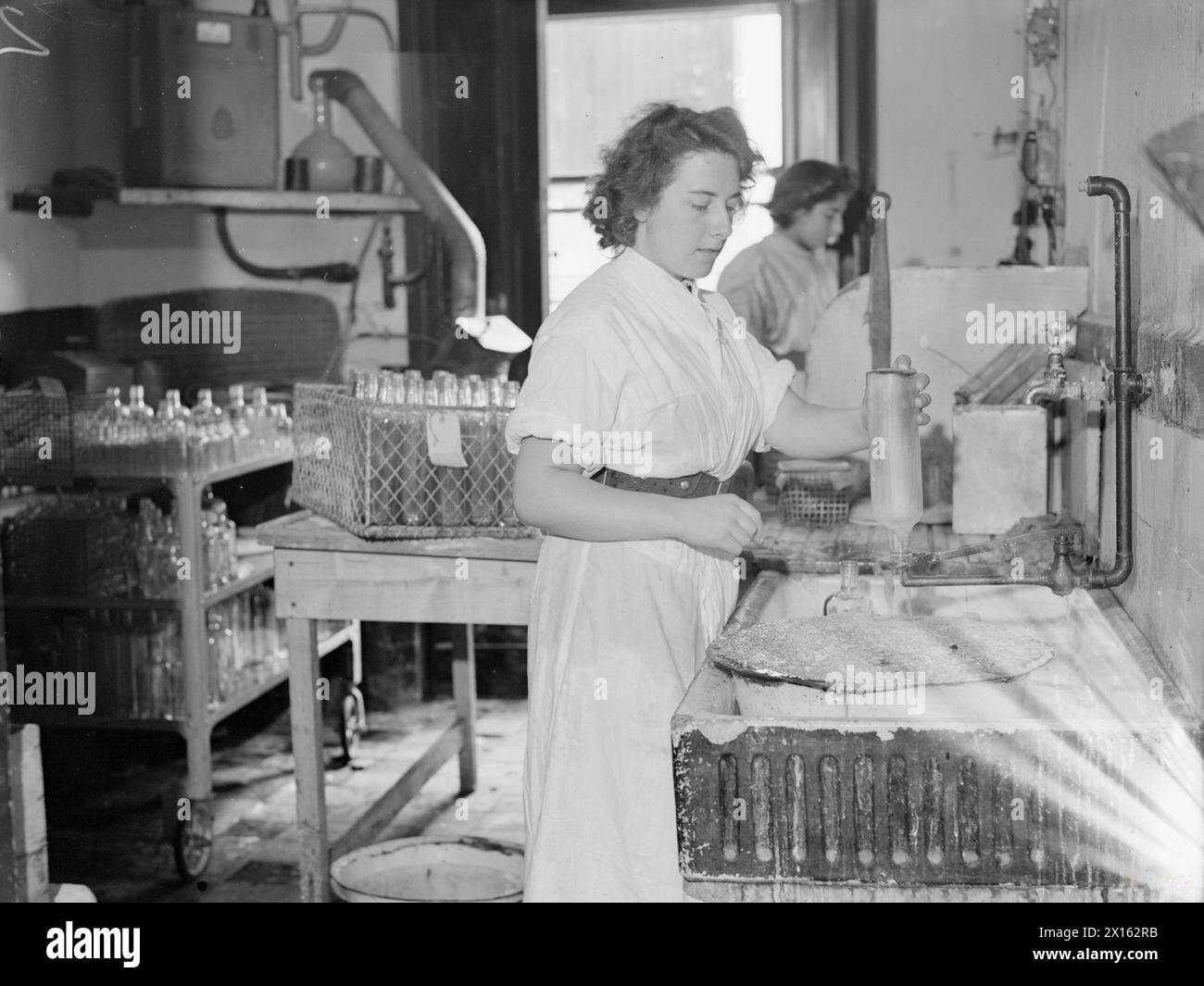 LA ROYAL NAVY LUI FAIT SA PROPRE PÉNICILLINE. 15 AOÛT 1944, ÉCOLE DE MÉDECINE DE LA ROYAL NAVY, CLEVEDON, SOMERSET. - Laver les bouteilles dans lesquelles pousse la pénicilline sur une période d'une semaine Banque D'Images