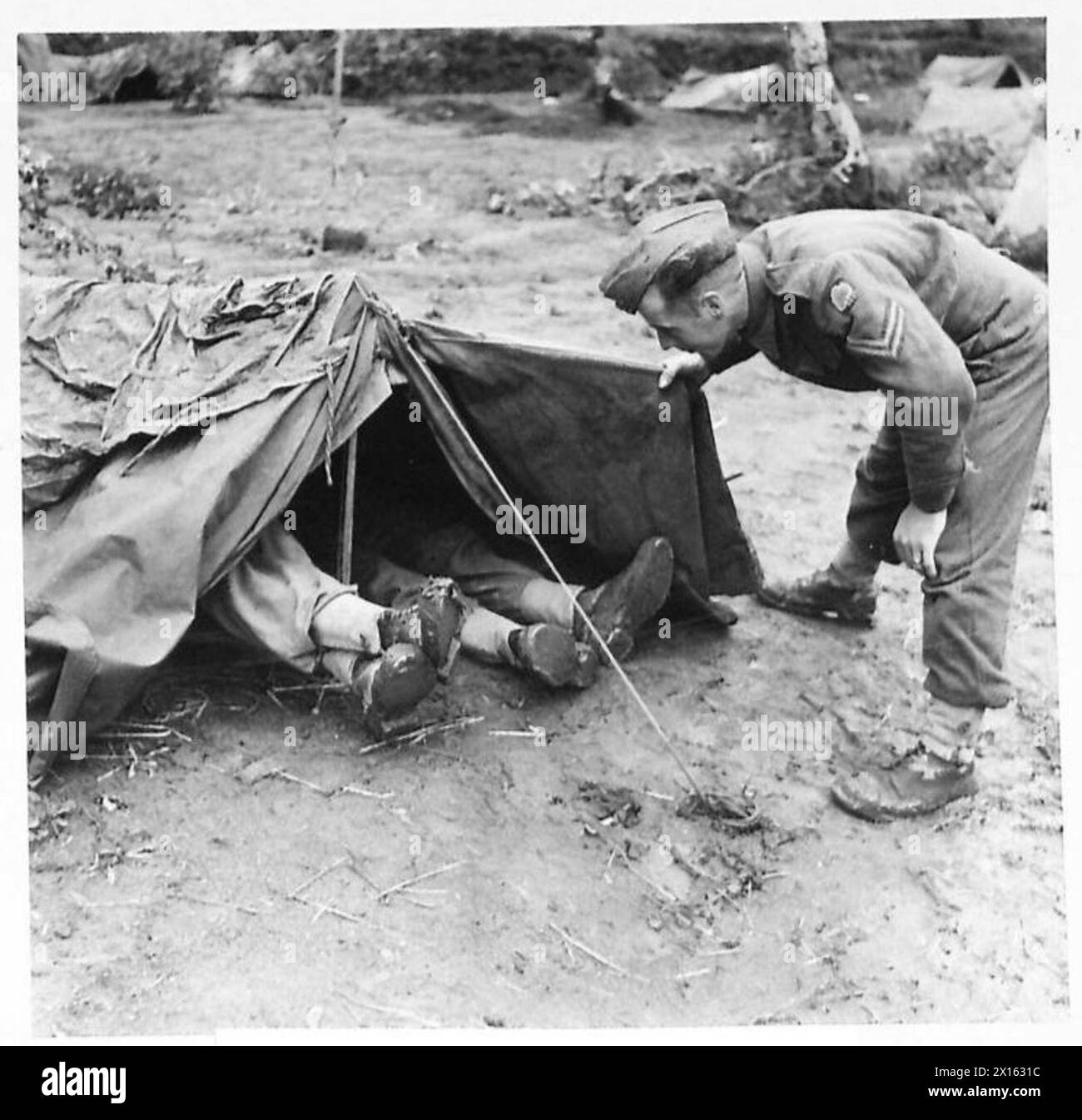 ITALIE : CINQUIÈME SECTEUR DE l'ARMYBRITISH - le Cpl G. Palmer d'Upper Hale, Farnham, fait sortir deux hommes endormis de leur bivouac British Army Banque D'Images