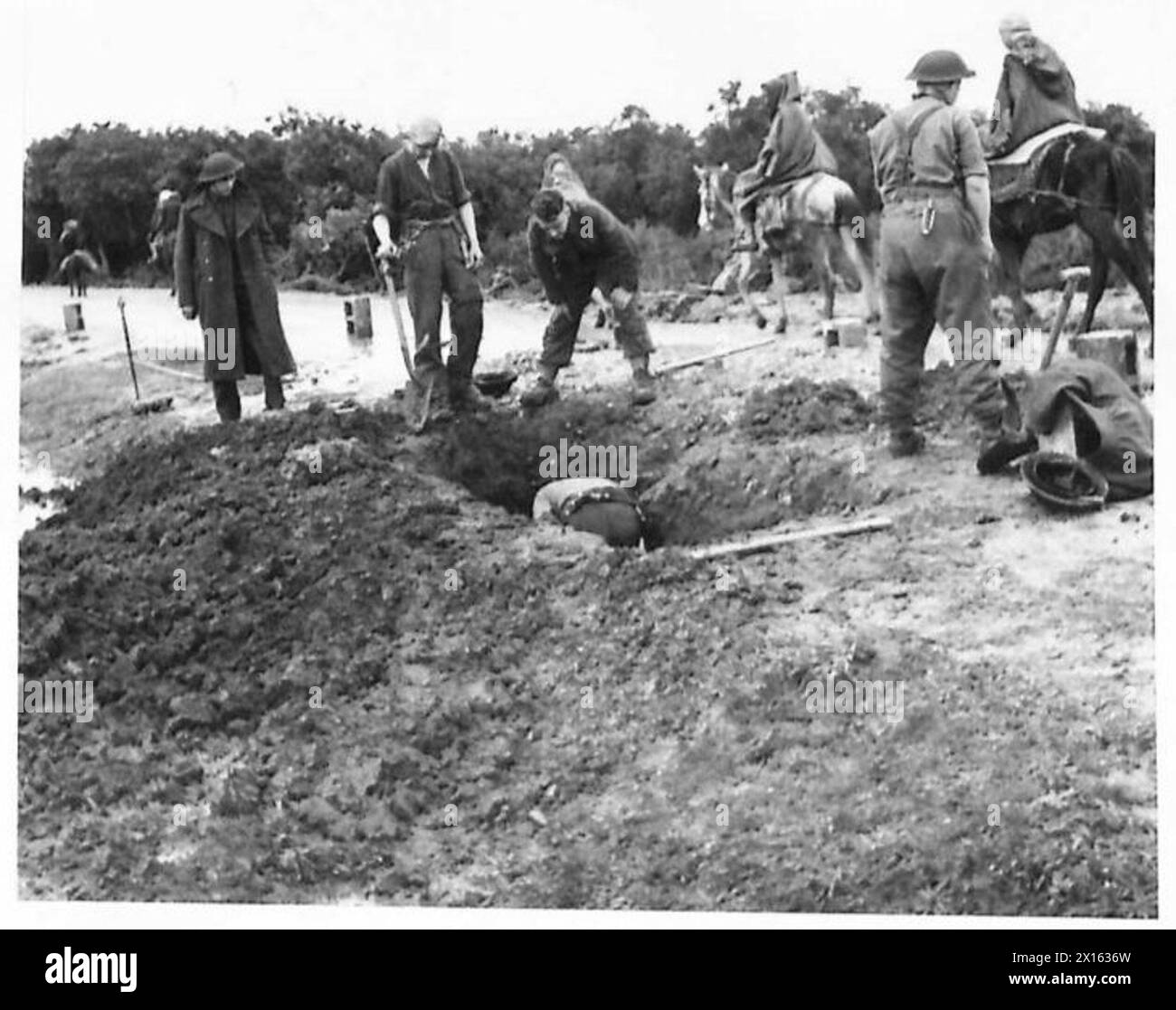 L'ARMÉE BRITANNIQUE DANS LA CAMPAGNE DE TUNISIE, NOVEMBRE 1942-MAI 1943 - les ingénieurs royaux creusent la bombe sur la route principale menant au front de Mateur. Les troupes de la 256th Field Company RE travaillèrent nuit et jour à creuser sur la route principale menant au front de Mateur pour enlever une bombe allemande non explosée de 500 lb qui retardait l'artillerie lourde et les fournitures nécessaires de toute urgence pour continuer le bombardement de la colline verte pendant l'une des actions, 1er janvier 1943 British Army, British Army, 1st Army, British Army, Royal Engineers Banque D'Images