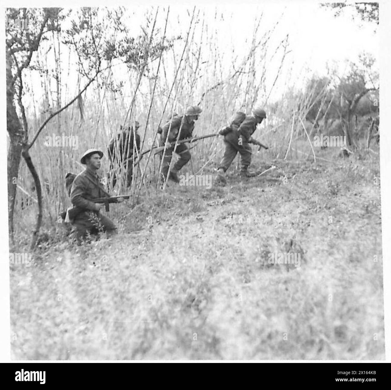 Une section d'infanterie avance sur un terrain dégagé sous le couvert du l/CPL. Cox armé d'un pistolet Tommy, y compris Pte. Drury, Pte. Durrant et Pte. Brooke d'Ipswich. Banque D'Images