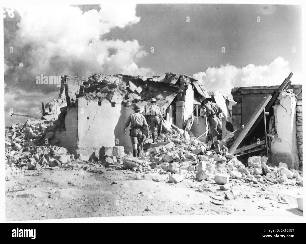 Un photographe officiel documente le personnel de l'armée britannique inspectant les débris de bombes dans le désert occidental à la suite d'une explosion. Banque D'Images