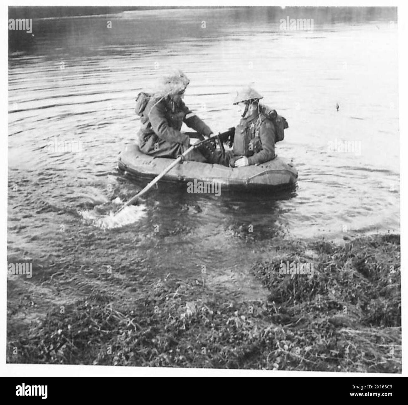 Deux fantassins de l'armée britannique naviguent sur une rivière dans un bateau en caoutchouc au cours d'un exercice d'entraînement, démontrant les techniques de traversée de la rivière et leur état de préparation opérationnelle. Banque D'Images