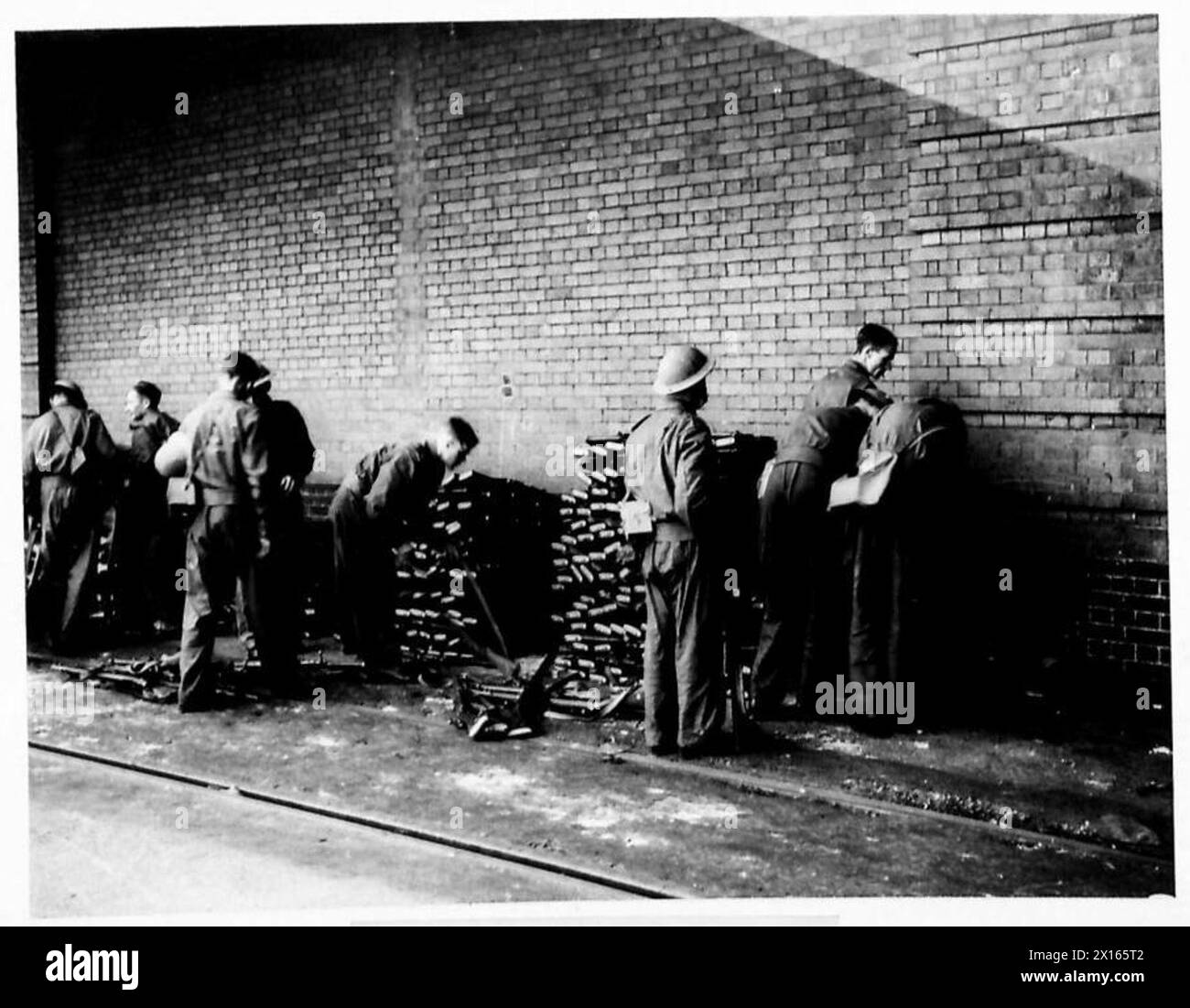 Les troupes jettent des fusils pendant une pause, qui sont collectés sous la supervision de l'armée britannique. Banque D'Images
