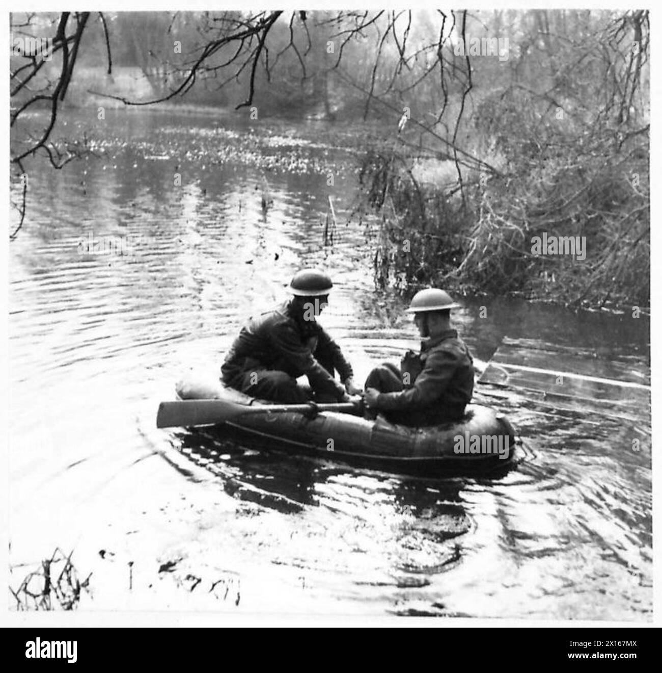 Les troupes du Commandement de l'est sont vues traverser une rivière à l'aide d'un bateau de reconnaissance en caoutchouc lors d'une visite par des correspondants de guerre. Banque D'Images
