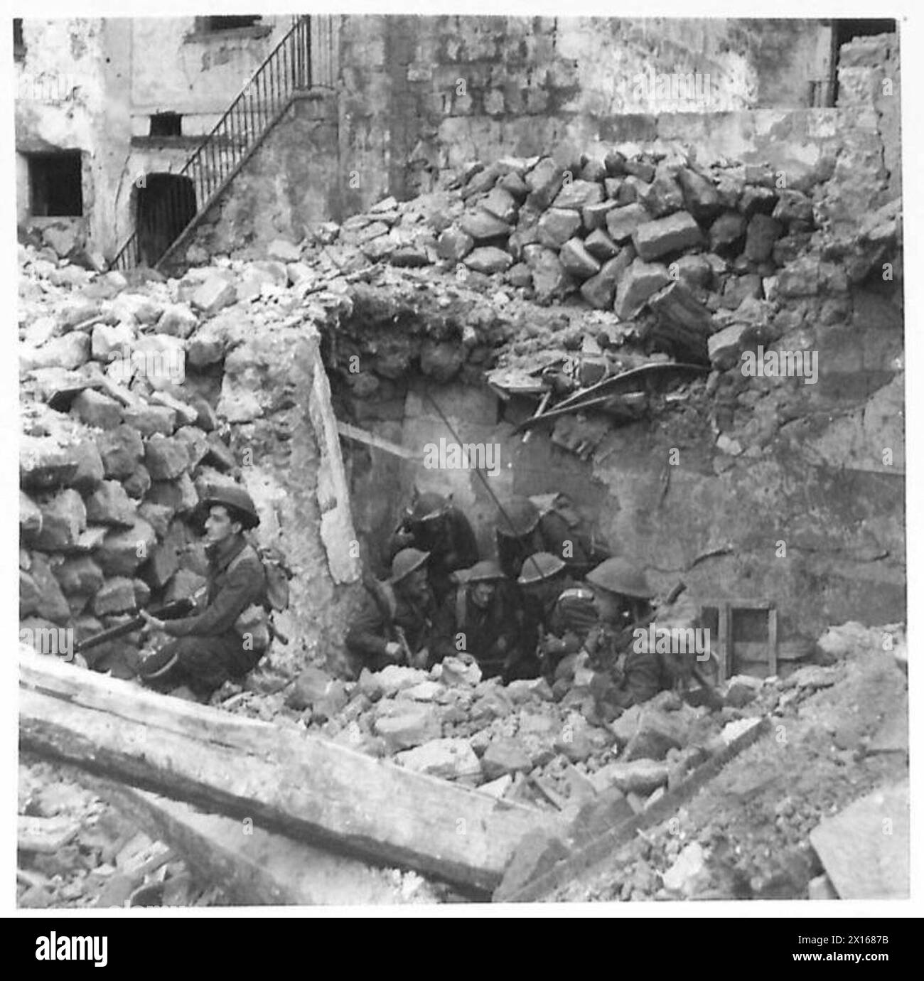 Le sous-lieutenant McCorquindale établit un quartier général dans une maison démolie et informe son commandant de peloton avec une photo aérienne pendant la bataille de Cassino, armée britannique. Banque D'Images
