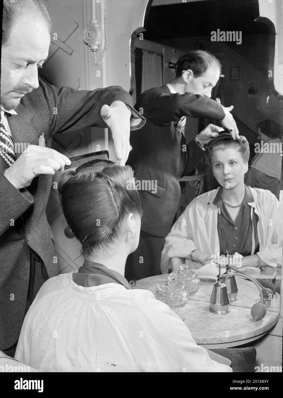 L'actrice Diana Wynyard se fait coiffer par Herman Steiner dans son salon Grosvenor Street à Londres, en 1944. Le salon est situé dans un sous-sol qui était auparavant un abri anti-aérien. Banque D'Images