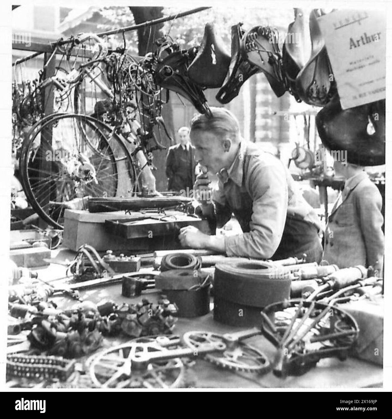 MARCHÉ DU DIMANCHE MATIN À BRUXELLES - cette série de photographies prises à Bruxelles illustre un marché typique du dimanche matin. Il est très semblable à notre Petticoat Lane où l'on peut acheter presque n'importe quoi. Des foules de folkloriques belges parcourent le marché à la recherche d'articles tels que des livres, du matériel, des pièces de vélo, des fruits et de nombreux autres articles dont ils ont besoin. Dans cette série est une vue générale d'une rue où le marché noir de Bruxelles s'est déroulé. Pas le marché noir comme nous le comprenons, mais où les Belges étaient approvisionnés en nourriture, etc., qui était interdit par les Allemands. [CES PHOTOGRAPHIES SONT À ILLUST Banque D'Images