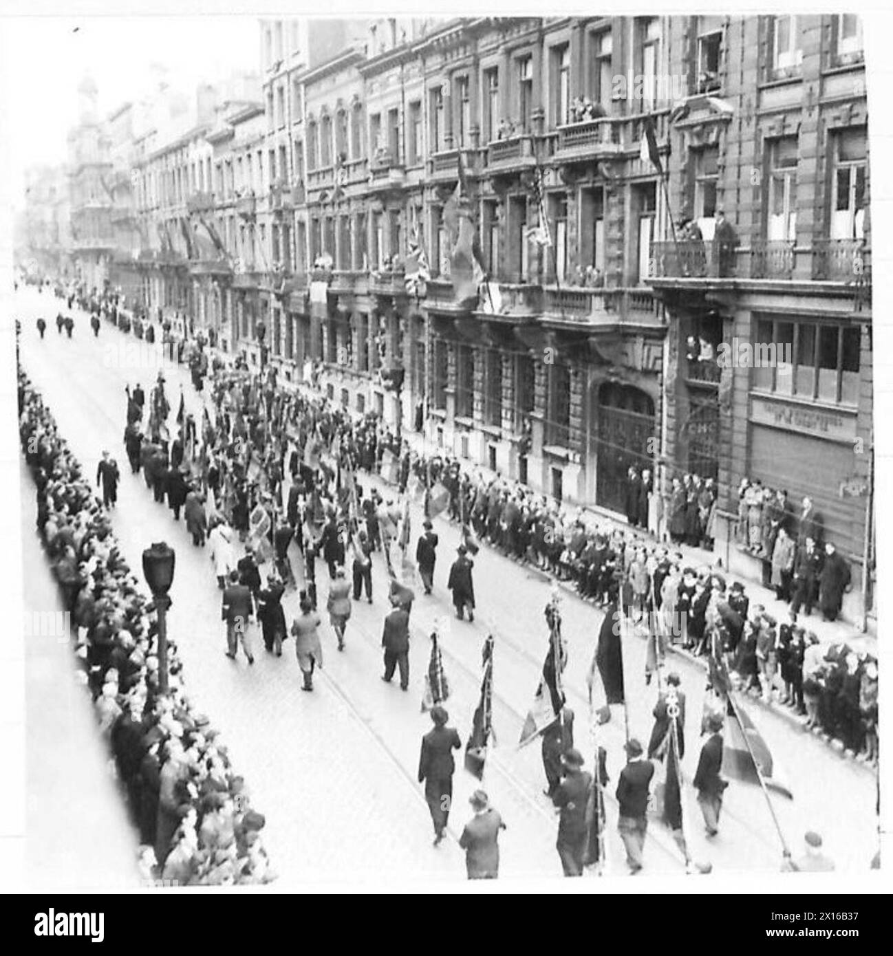 FUNÉRAILLES CÉRÉMONIELLES DE LA POLICE BRUXELLOISE FUSILLÉE PAR LES ALLEMANDS - partie du cortège passant par la rue bordée de personnes British Army, 21st Army Group Banque D'Images