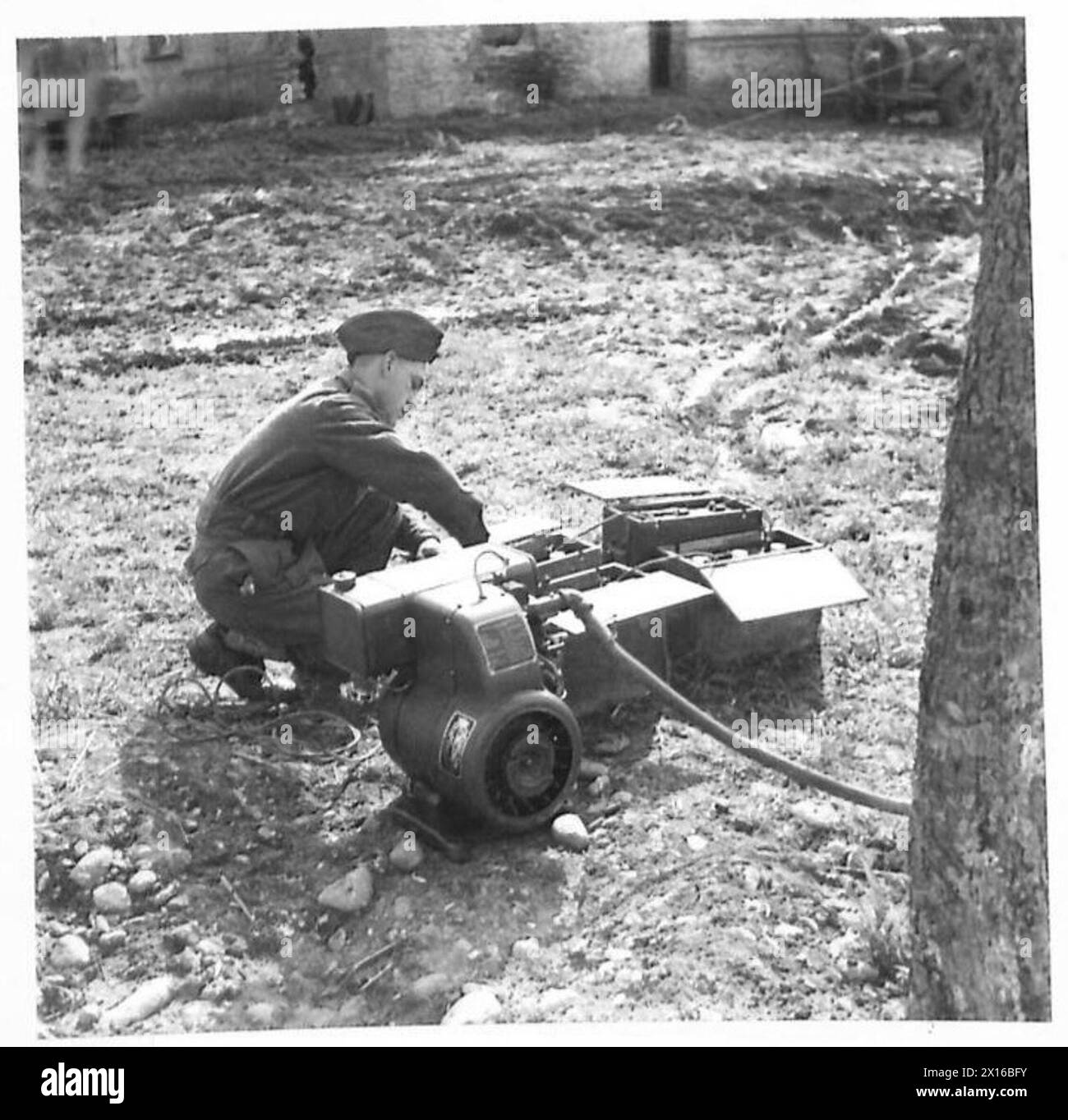 Un électricien connecte les batteries à un petit générateur de moteur à essence, fournissant l'alimentation pour les appareils sans fil dans un quartier général de la division de l'armée britannique pendant la première Guerre mondiale Banque D'Images