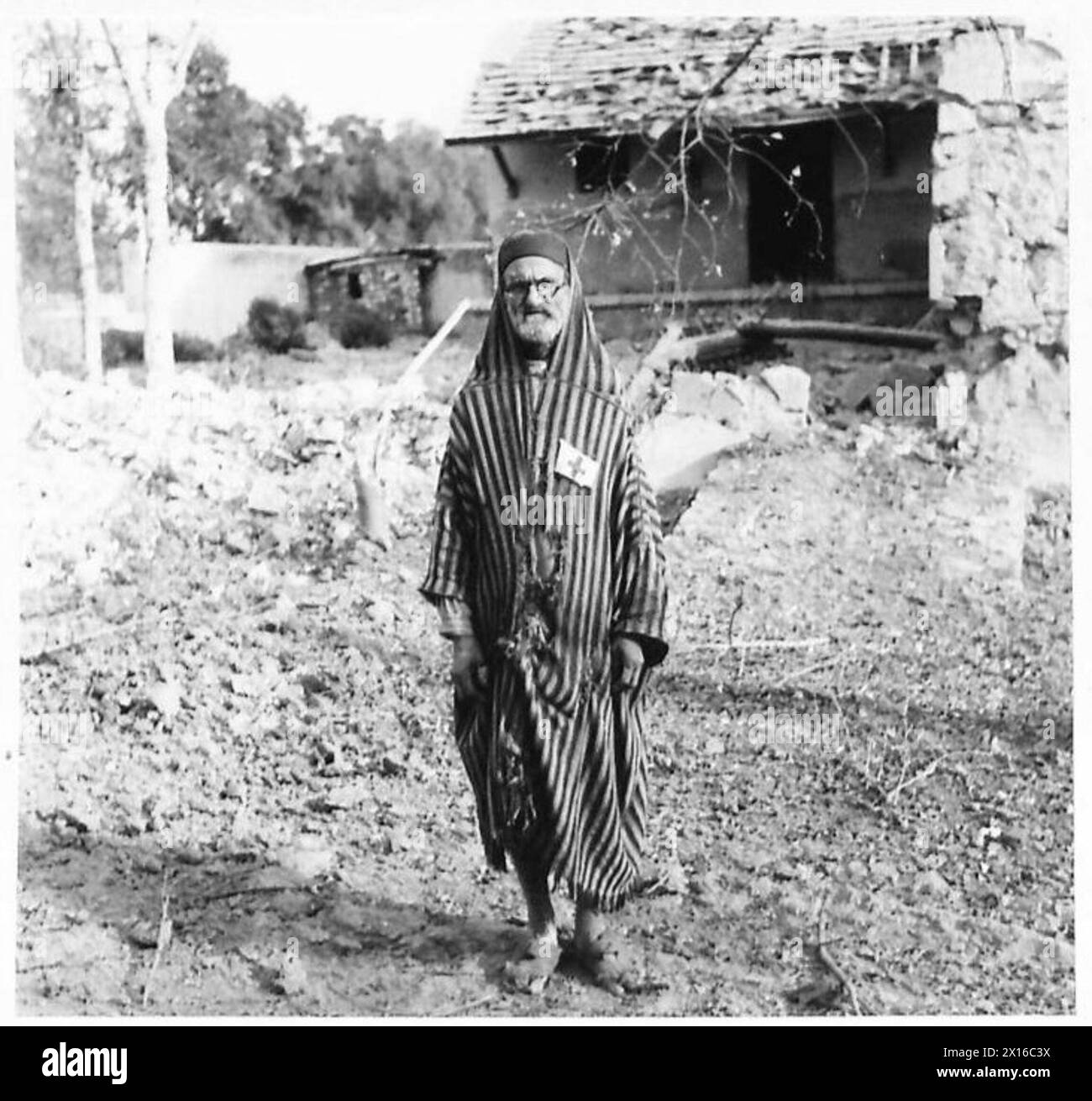 Un travailleur arabe local assiste la Croix-Rouge britannique lors des opérations à Tabarka, le 29 novembre 1942, apportant secours et soutien pendant la campagne de Tunisie. Banque D'Images