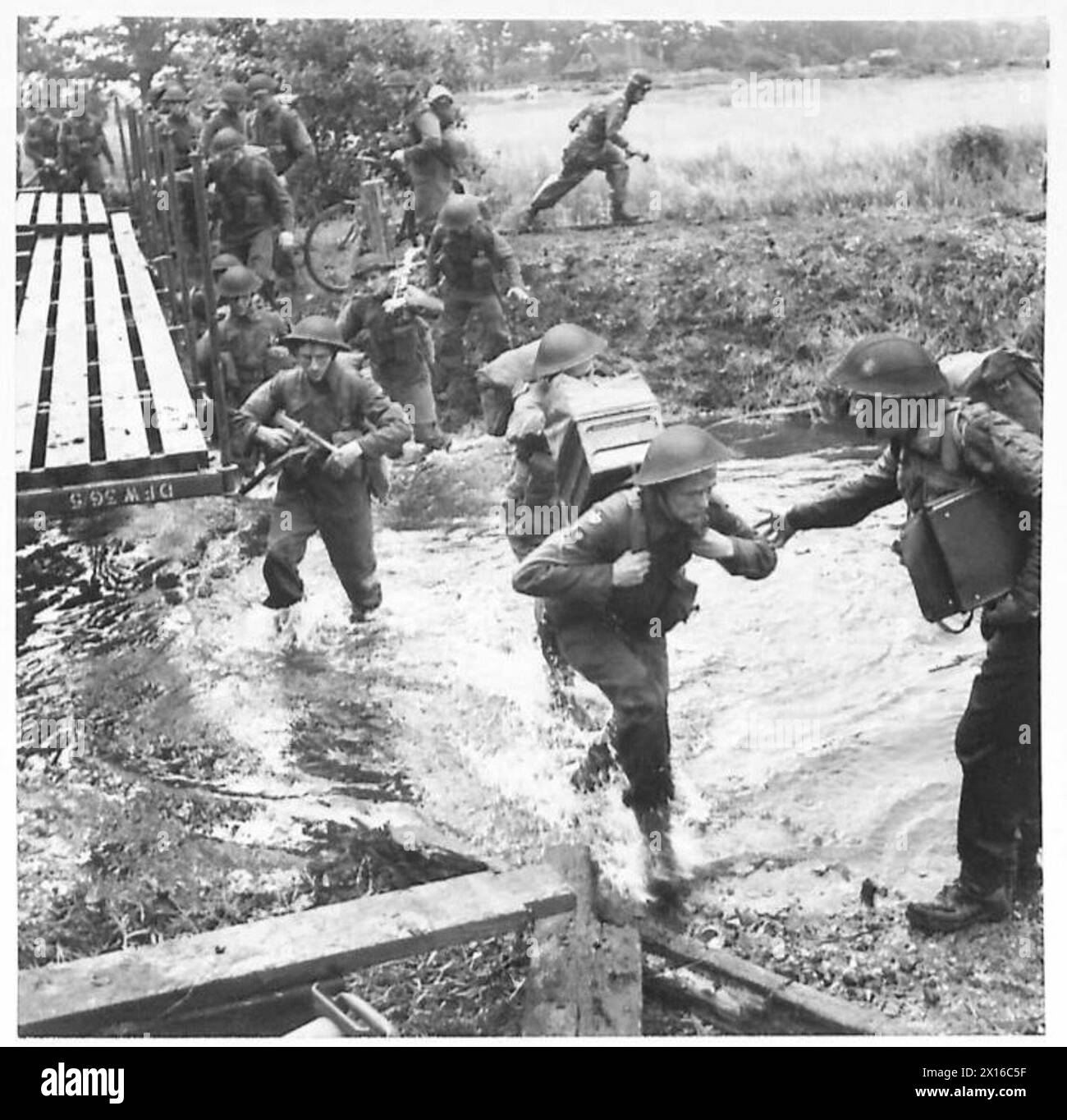 Au cours d'un exercice à grande échelle dans le Commandement de l'est, un officier aide un soldat à traverser une rivière tout en transportant un talkie-walkie Banque D'Images