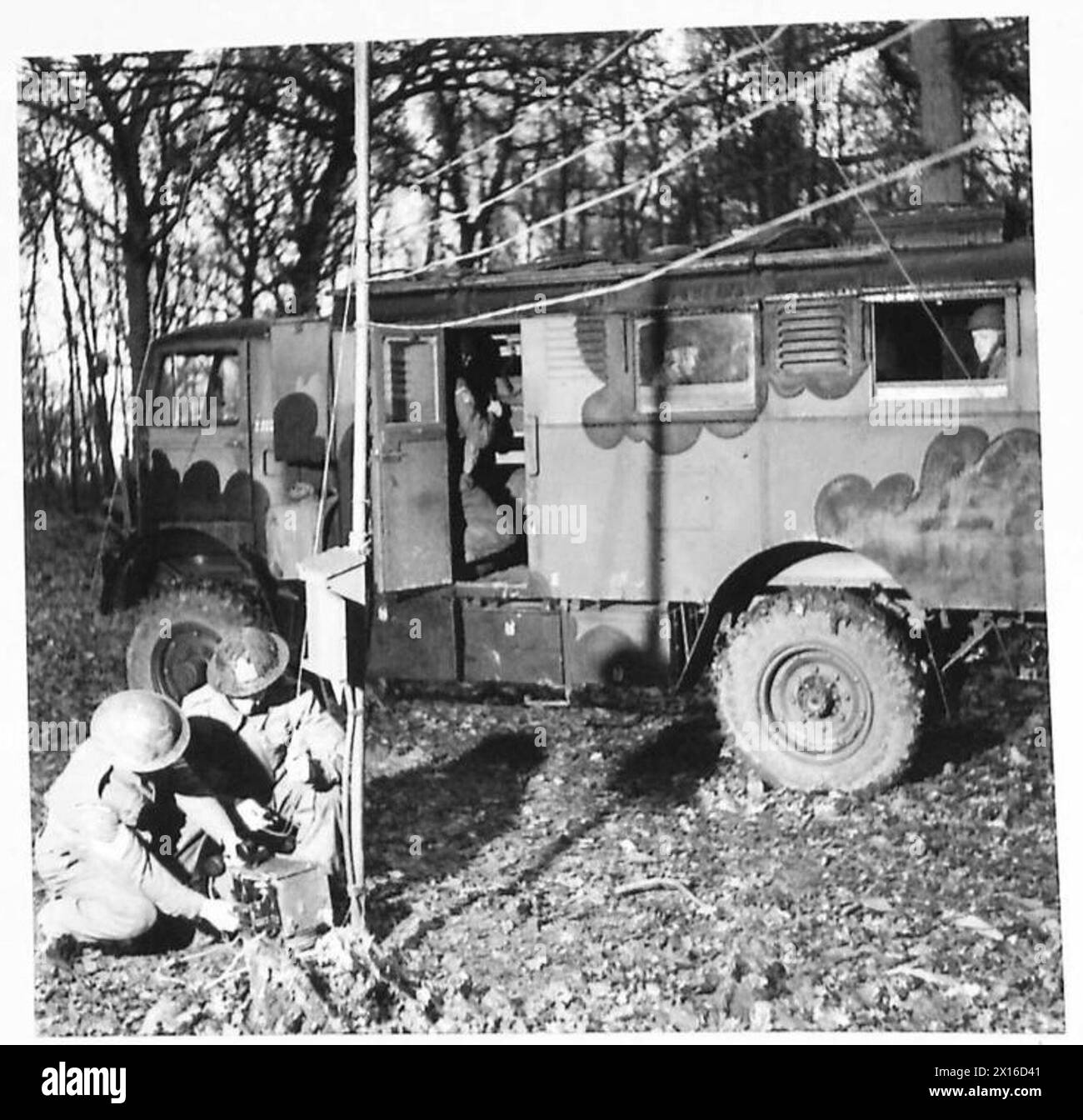 ROYAL SIGNALS TERMINAL EQUIPMENT VEHICLE - Un bureau de signalisation mobile et un téléphone dissimulé dans un bois. Les lignes des signaux Royal testent les câbles de terrain au niveau d'une boîte de test sur un pôle terminal. Les lignes menant à l'échange sont généralement enterrées pour la sécurité et la dissimulation, mais dans ce cas quatre câbles de terrain ont été conduits sur les poteaux de l'armée britannique Banque D'Images