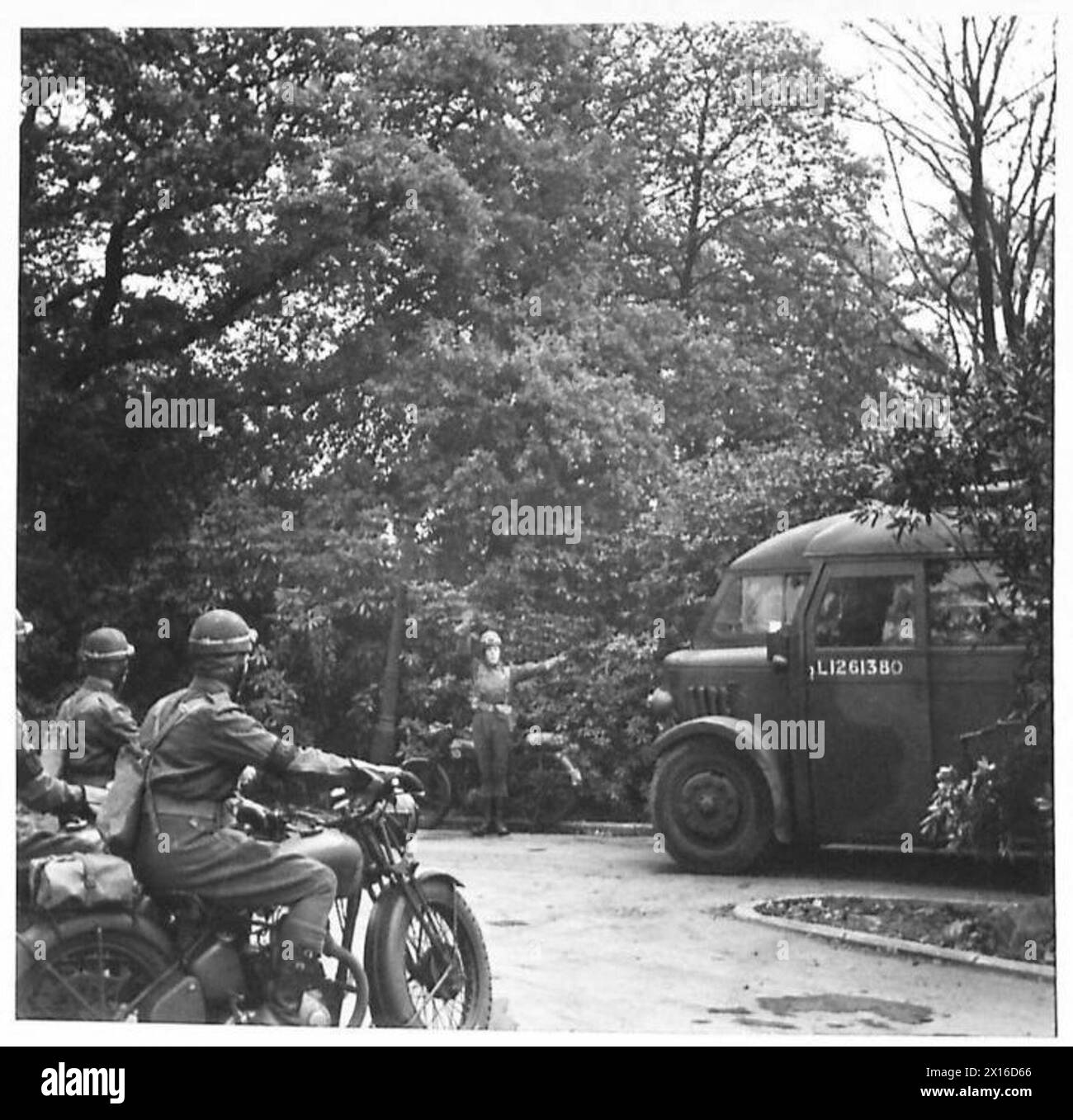 Lors d'une visite à un bataillon de la Garde écossaise, un officier de police régimentaire de motocyclette dirige la circulation à un carrefour, illustrant le contrôle de la circulation interne et la gestion de l'unité. Banque D'Images