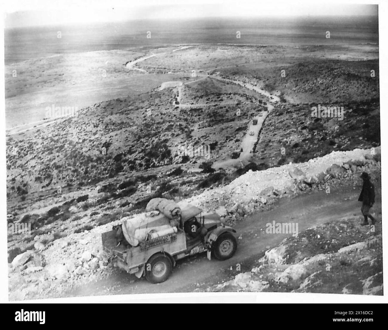 Les hommes et le matériel de l'armée britannique se déplacent le long des routes à travers un terrain vert près de Derna, faisant la transition des conditions désertiques, en formations de marche. Banque D'Images