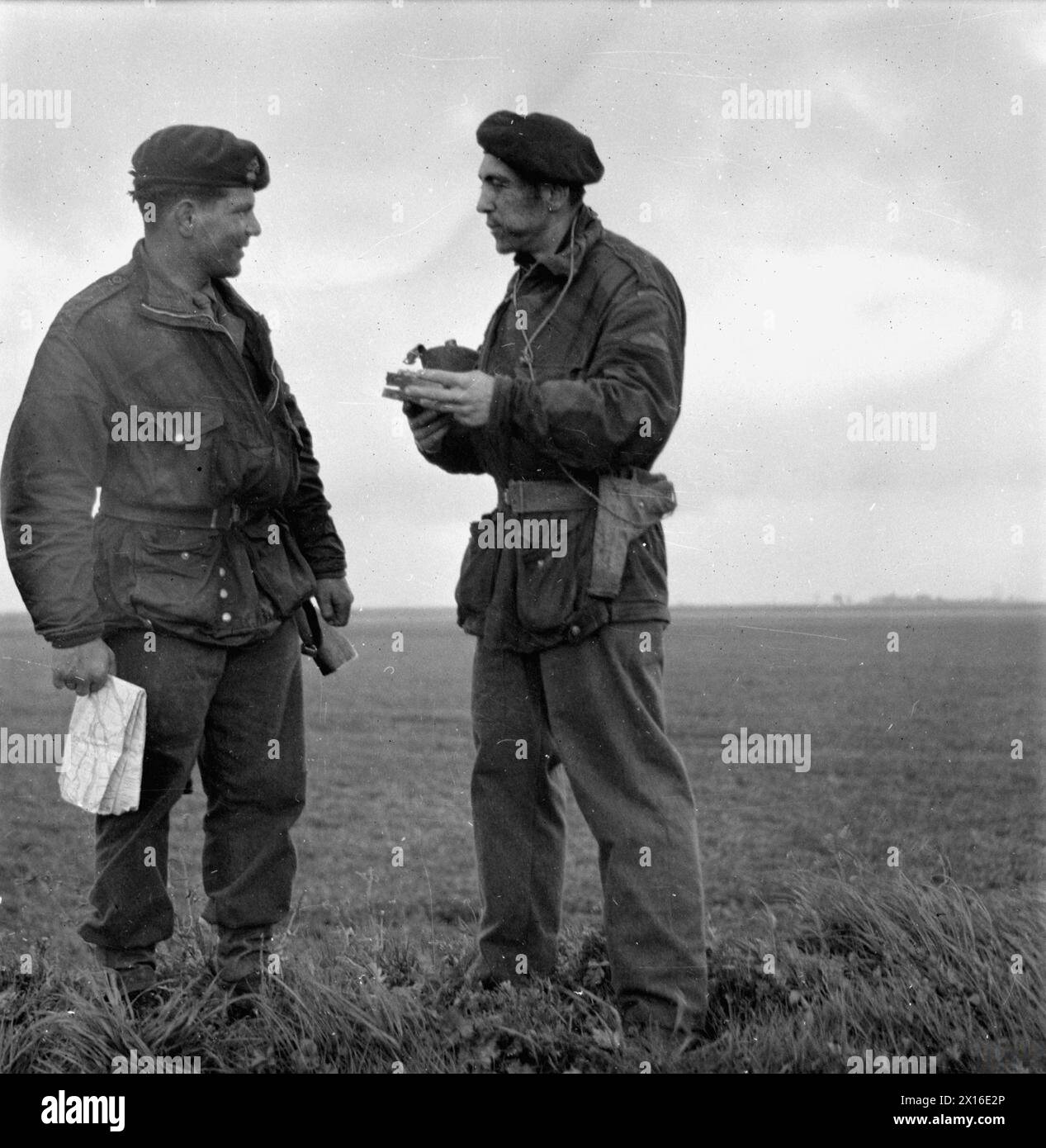 RAID DE COMMANDOS DE LA MARINE ROYALE EN FORCE À TRAVERS LA MAAS, AVRIL 1945. - Le Major 'Pat' Wall, RM, et le Lieutenant Kingsley, un commandant de l'armée, qui a mené une patrouille à travers la rivière avant le passage principal. Pendant deux jours, cette patrouille de Marines se maintint de l'autre côté de la rivière sans nourriture, infligeant des pertes aux patrouilles allemandes et pataugant jusqu'à leurs épaules à travers le labyrinthe de ruisseaux qui croisent le delta de Biesboch entre la Maas et le Waal. Après avoir rejoint le parti principal, ils reçoivent leur première nourriture pendant deux jours Banque D'Images