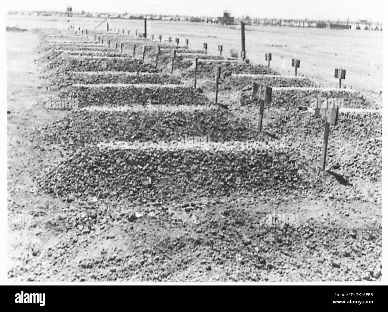 Un cimetière près d'un camp de prisonniers de guerre libyens où les tombes sont marquées avec des numéros au lieu de noms. Le cimetière est entretenu de manière ordonnée, reflétant les pratiques structurées de tenue de registres du camp. Banque D'Images